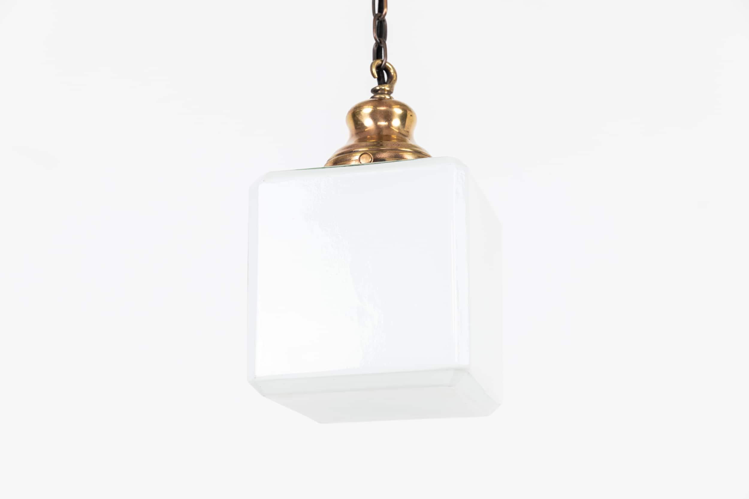 An incredibly elegant art deco cubed opaline pendant lamp. c.1930.

Thick pressed white opaline glass light shade with period brass gallery. These look fantastic in a porch with your door number/named painted on.

