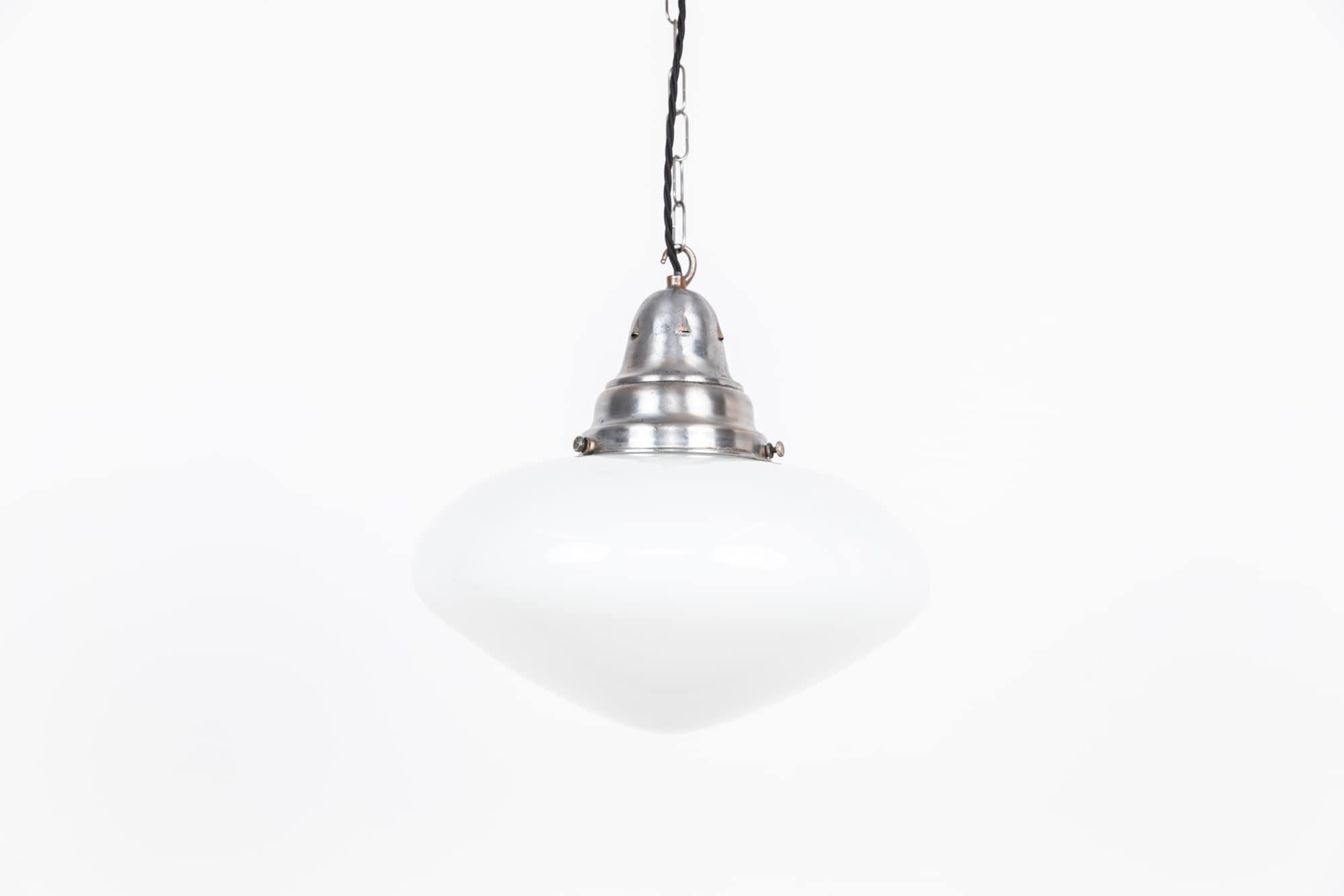 

An elegantly shaped opaline glass pendant light with gallery. c.1930

Of ovaloid form, white opaline glass and period tarnished nickel plated gallery.

Rewired with 1m of black twisted flex.

