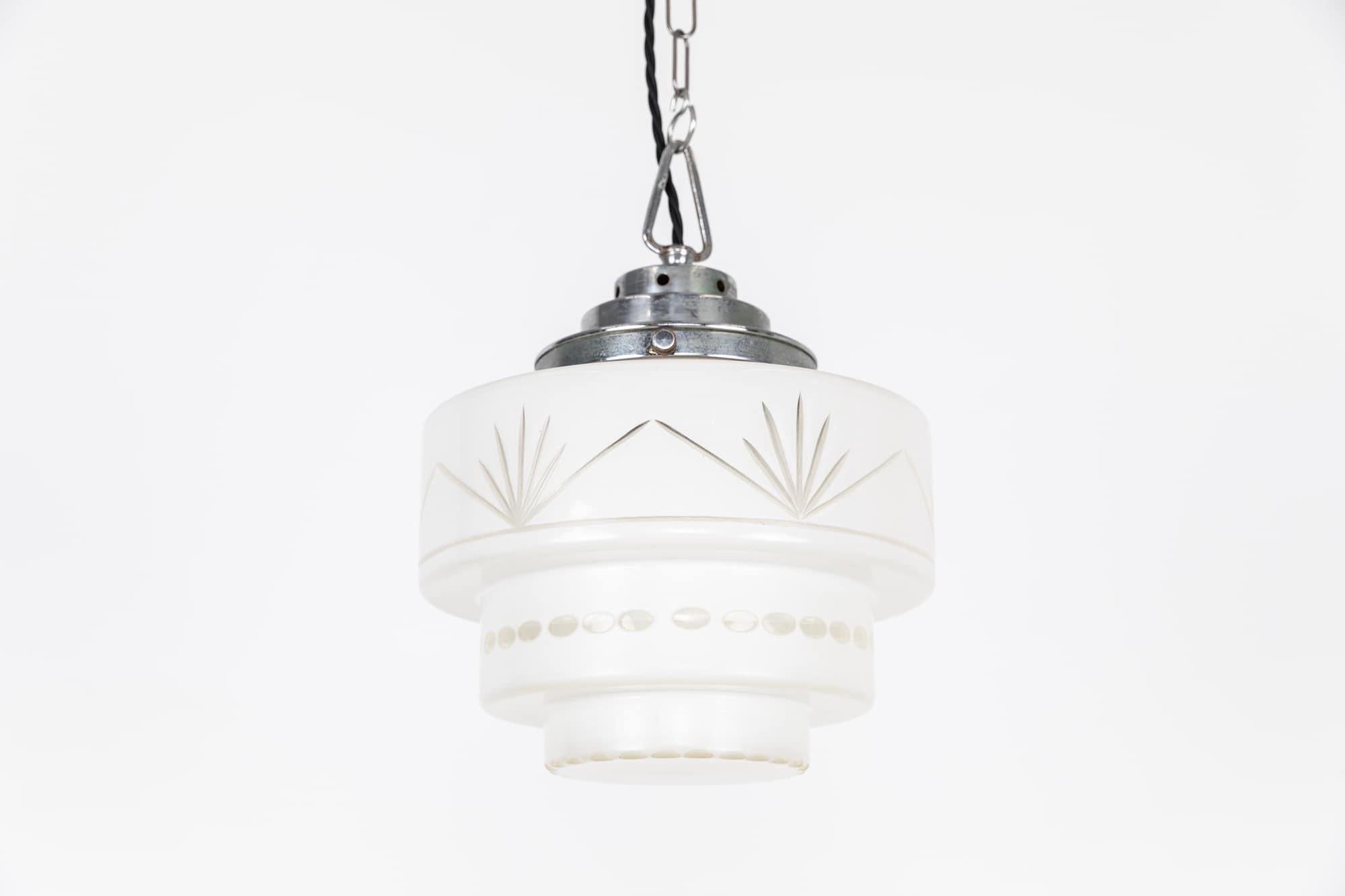 

An elegantly formed cut glass art deco opaline glass pendant light. c.1940

Made by GEC to their usual high standard of quality. Original heavy duty chromed gallery supporting the cut glass cylindrical shade.

Rewired with 1m of black twisted
