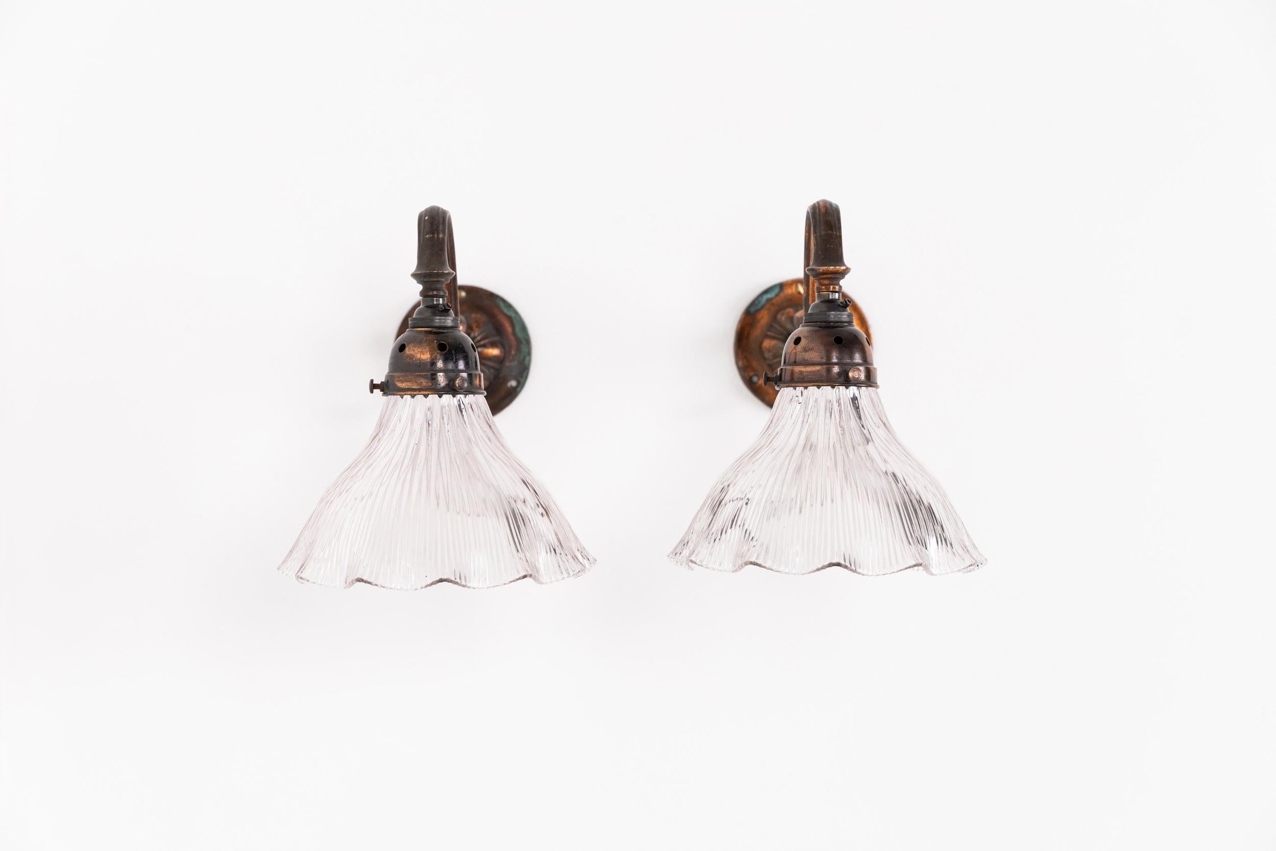 

A pair of oxy-copper plated swan neck wall lights made in England by GEC. c.1930

Brass construction with beautifully tarnished copper plate. Prismatic glass Holophane lamp shades and original copper galleries. Priced as a pair.

Rewired to