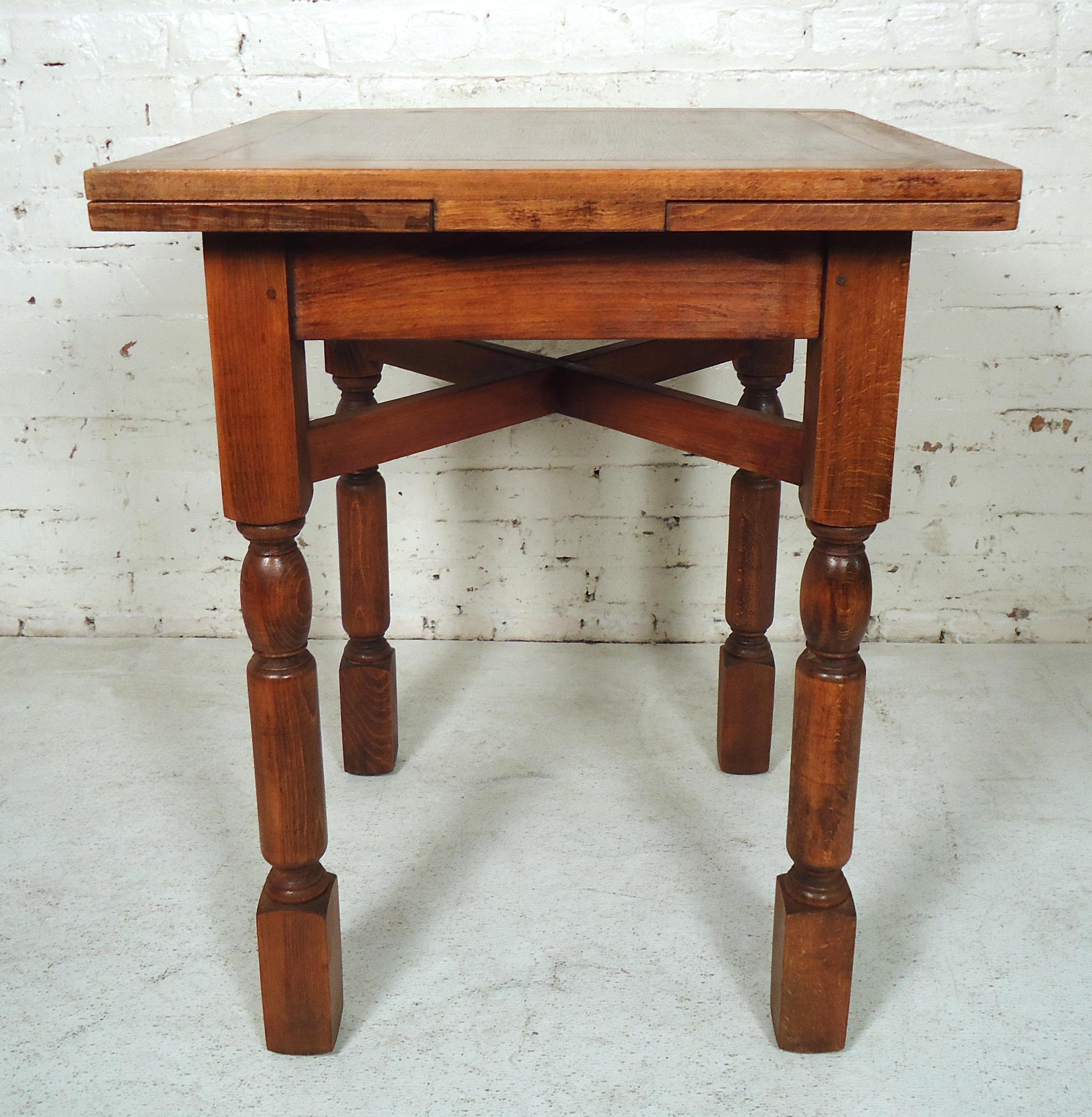 Vintage antique dining table features a square top, extendable leaves, and sturdy legs. Two 9