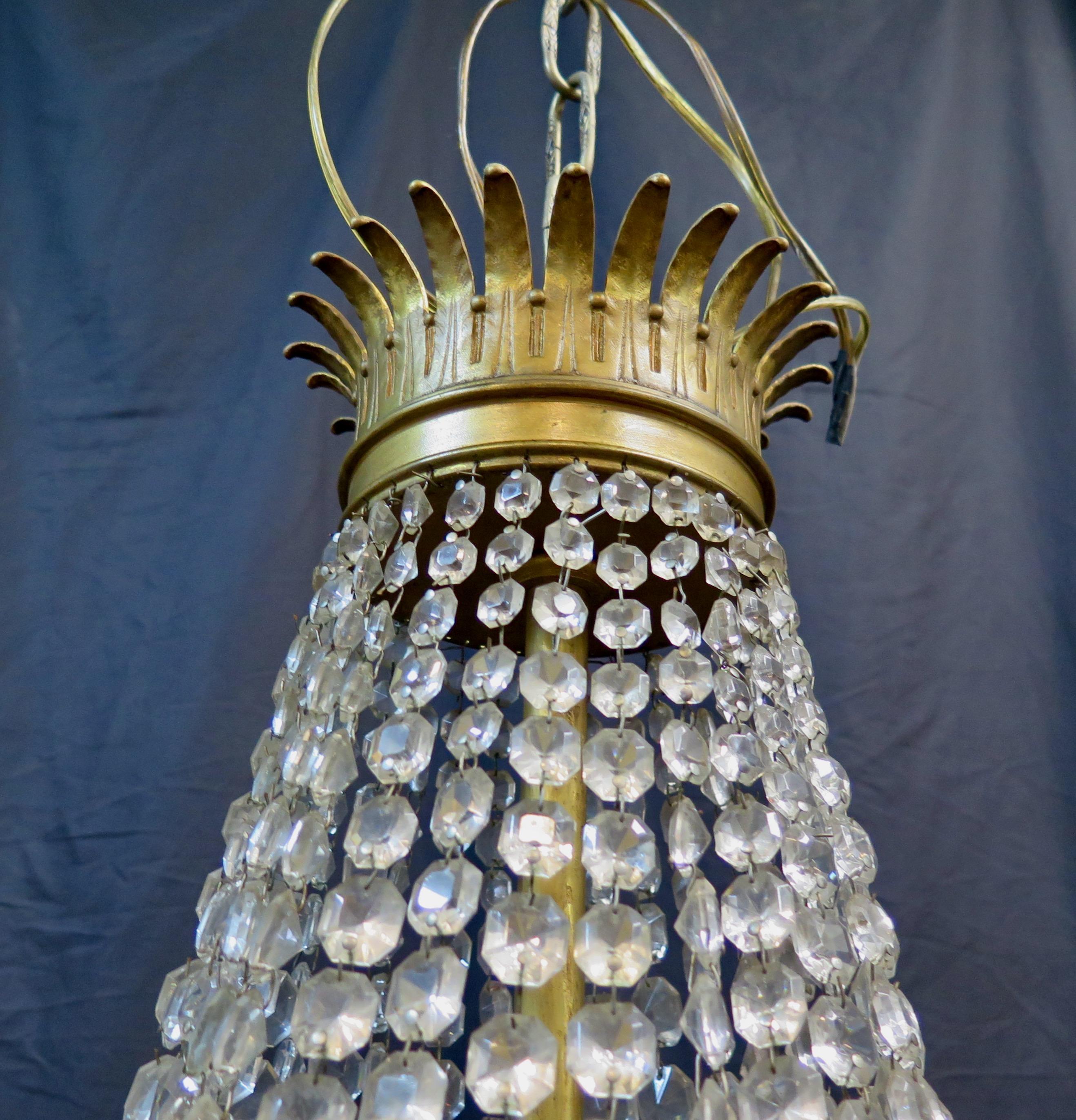 sta lámpara francesa vintage de bronce dorado y cristal de finales del siglo XIX está bellamente diseñada como una elegante araña de comedor formal. Está engalanada con guirnaldas de cristal que caen en cascada desde una corona decorativa de bronce.