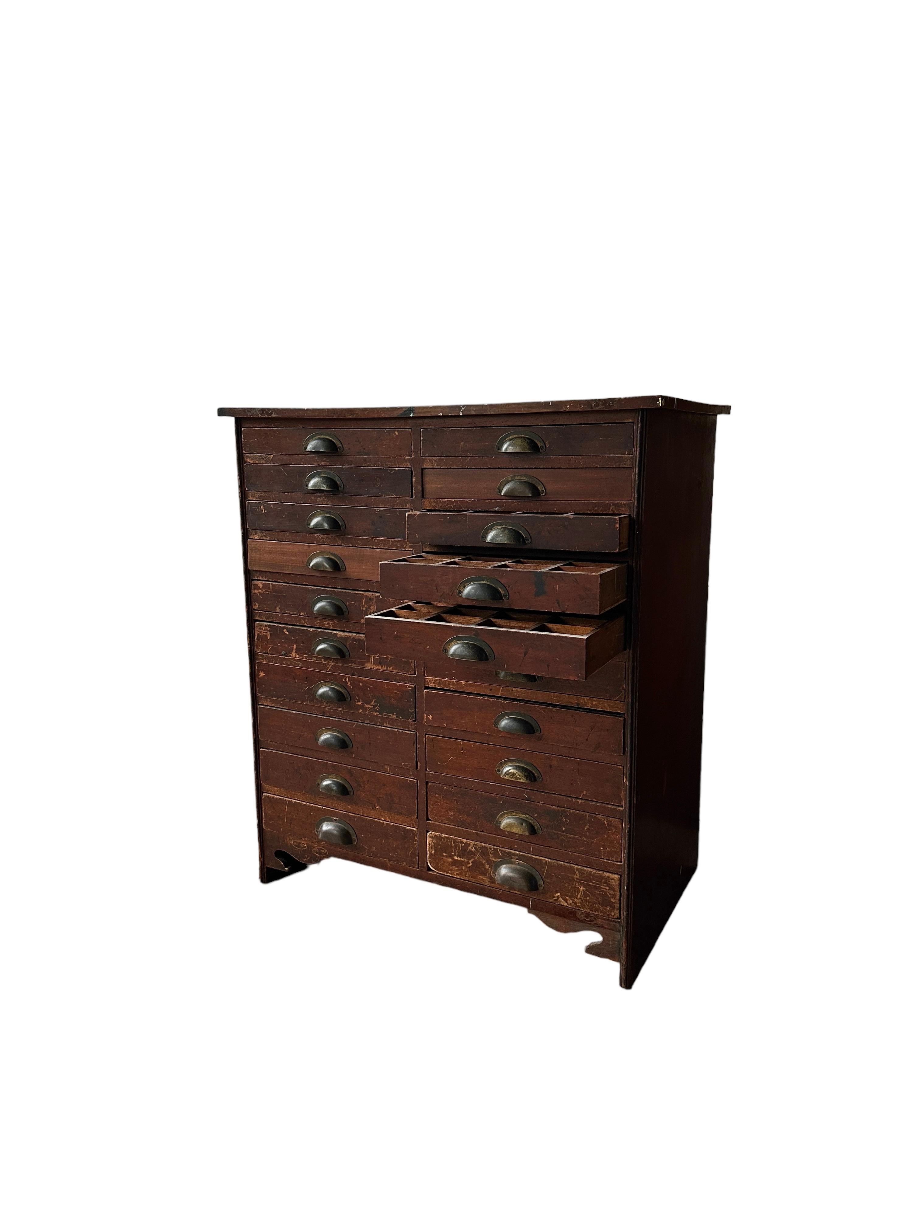  Precioso juego antiguo de cajones de taller de relojero, Inglaterra, hacia 1950. 
- Hay 20 cajones graduados, todos ellos con tiradores originales de latón.  Todos los cajones tienen separadores de madera en su interior, que originalmente se