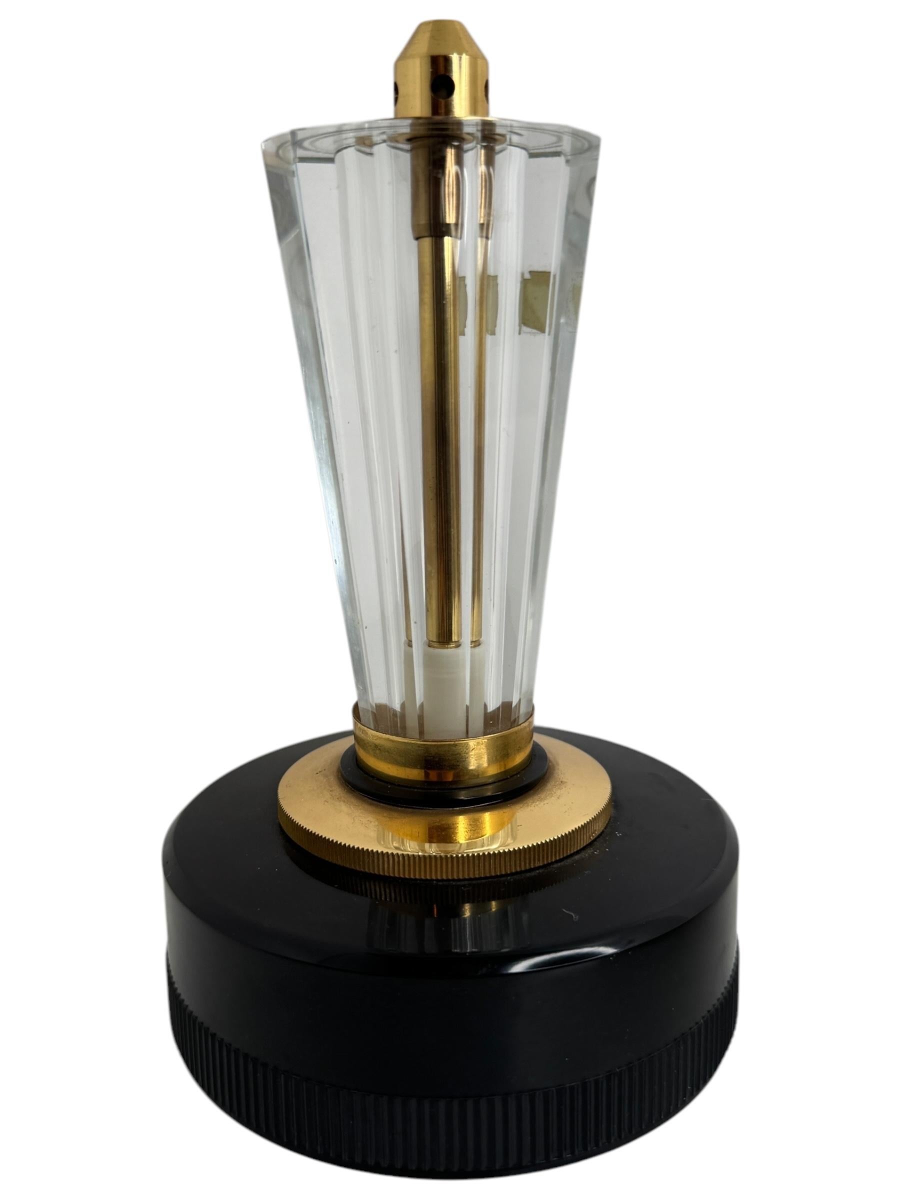 Allumoir à gaz et électrique de table vintage en cristal. En très bon état. Ce briquet exquis témoigne de l'opulence et de l'artisanat du milieu du XXe siècle. 
La base du briquet est façonnée à partir d'un noir immaculé rétroéclairé, offrant une