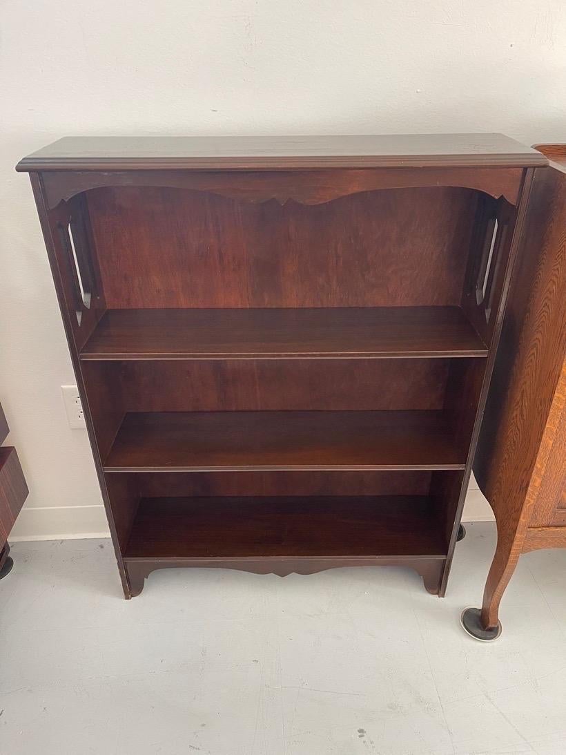 This Bookshelf has carved wood detailing and cutouts around the frame. Slender silhouette, petite sizing. Three sturdy shelves. Vintage Condition Consistent with Age as Pictured.

Dimensions. 30 W ; 8 D ; 38 H