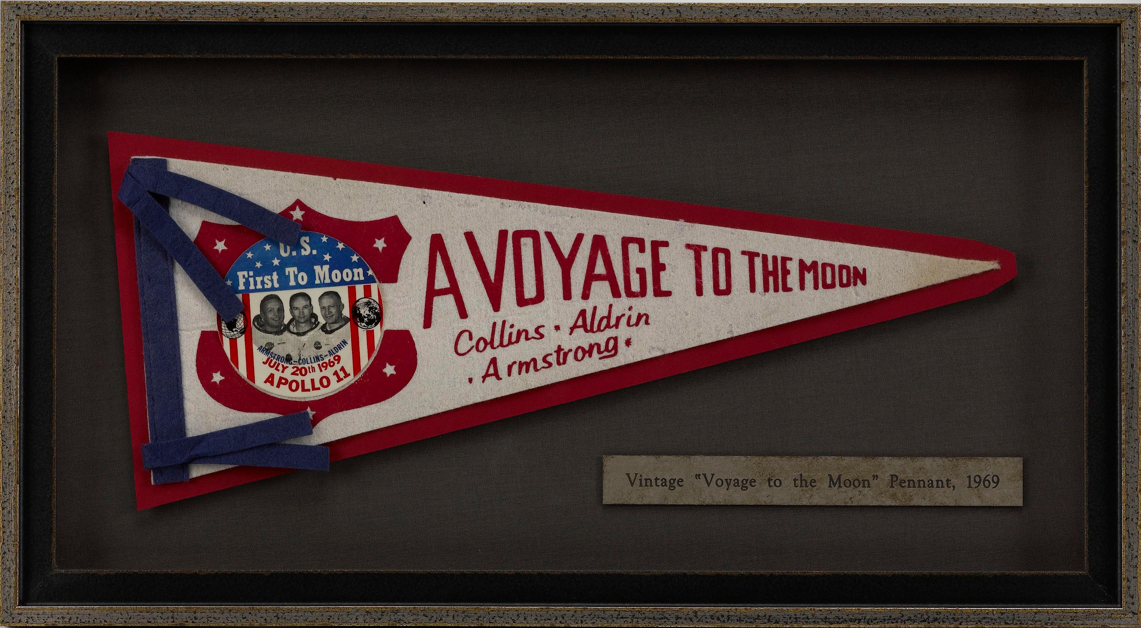 Presented is a vintage pennant from 1969 highlighting the Apollo 11 space mission. The felt pennant features a white field with the words 