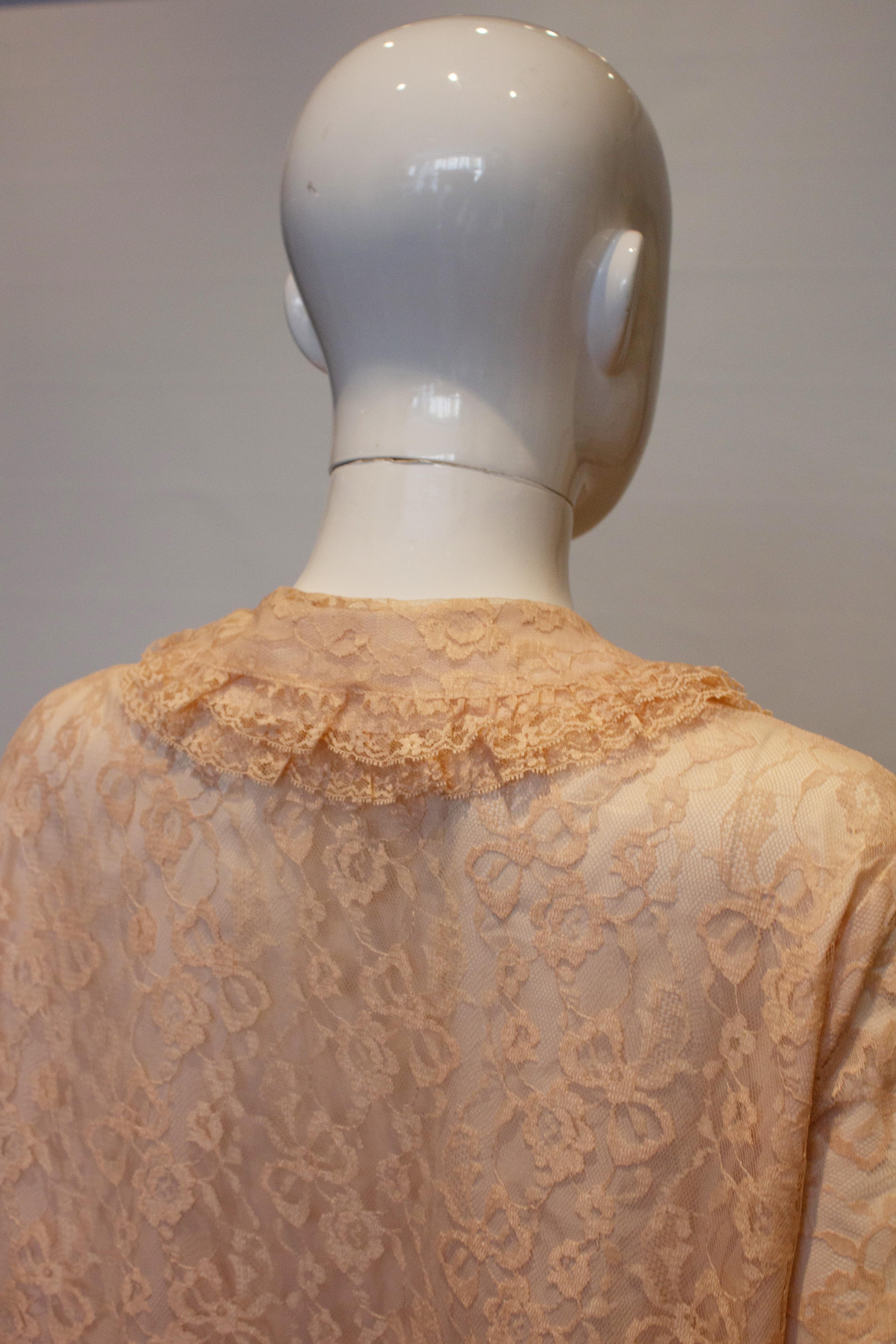 A pretty and easy to wear apricot/pink vintage lace dress . The dress has a round collar, front popper opening ,and elbow  length sleaves.  It has a frill at the hem and is fully lined with ribbon detail at the cuff. Measurements: bust  up to 44'', 