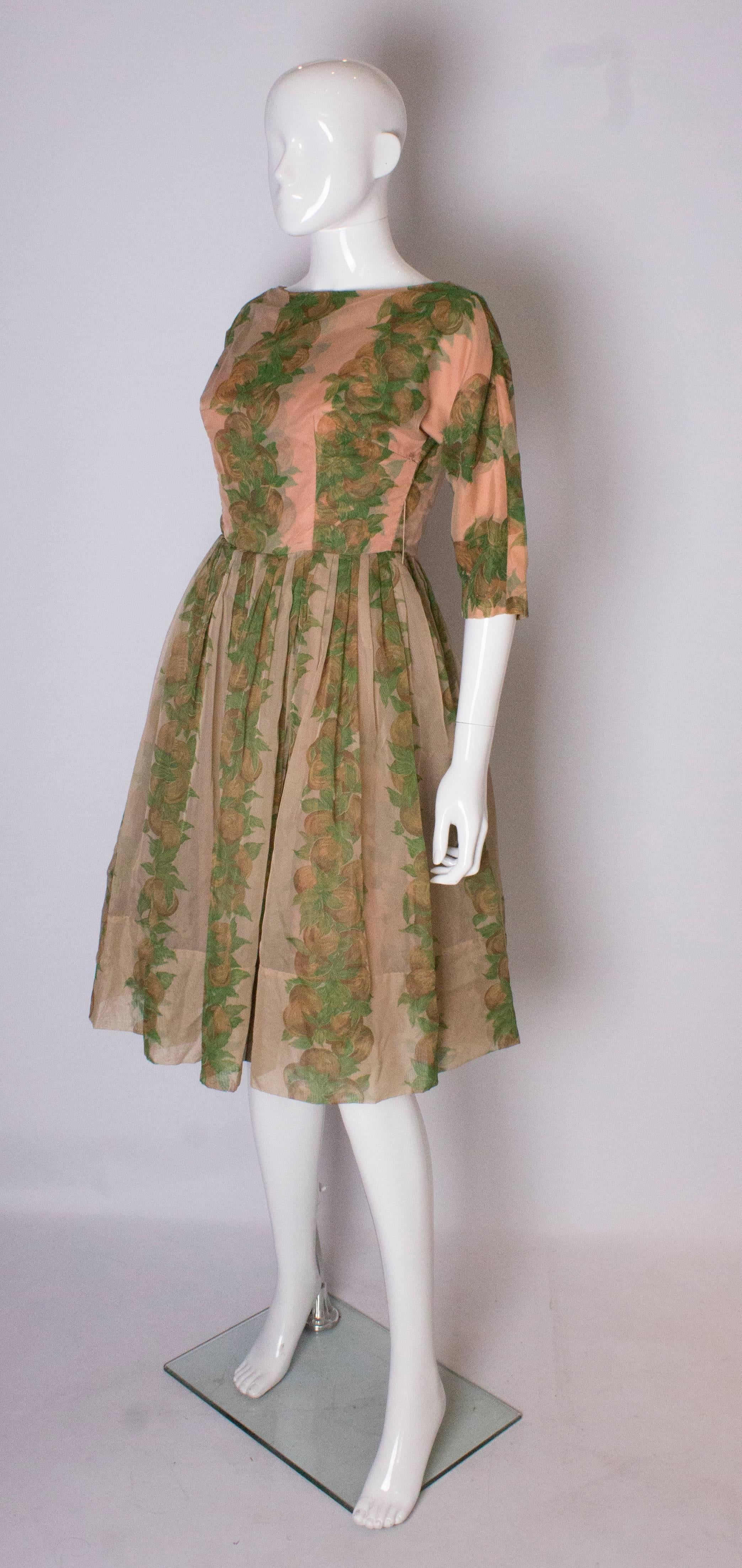 A Vintage 1950s Apricot, Green and Brown print swing cinch party dress In Good Condition In London, GB