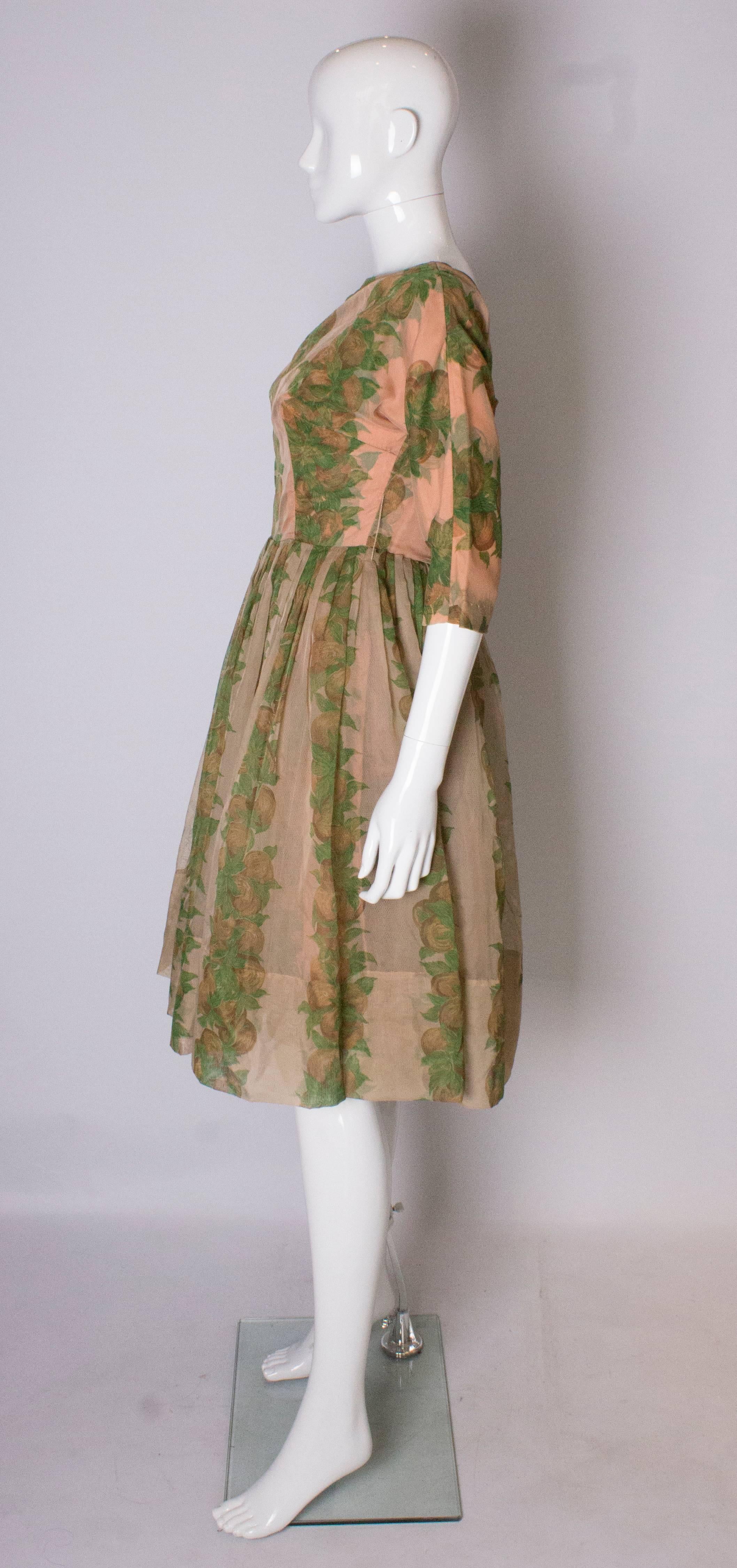 A Vintage 1950s Apricot, Green and Brown print swing cinch party dress 1