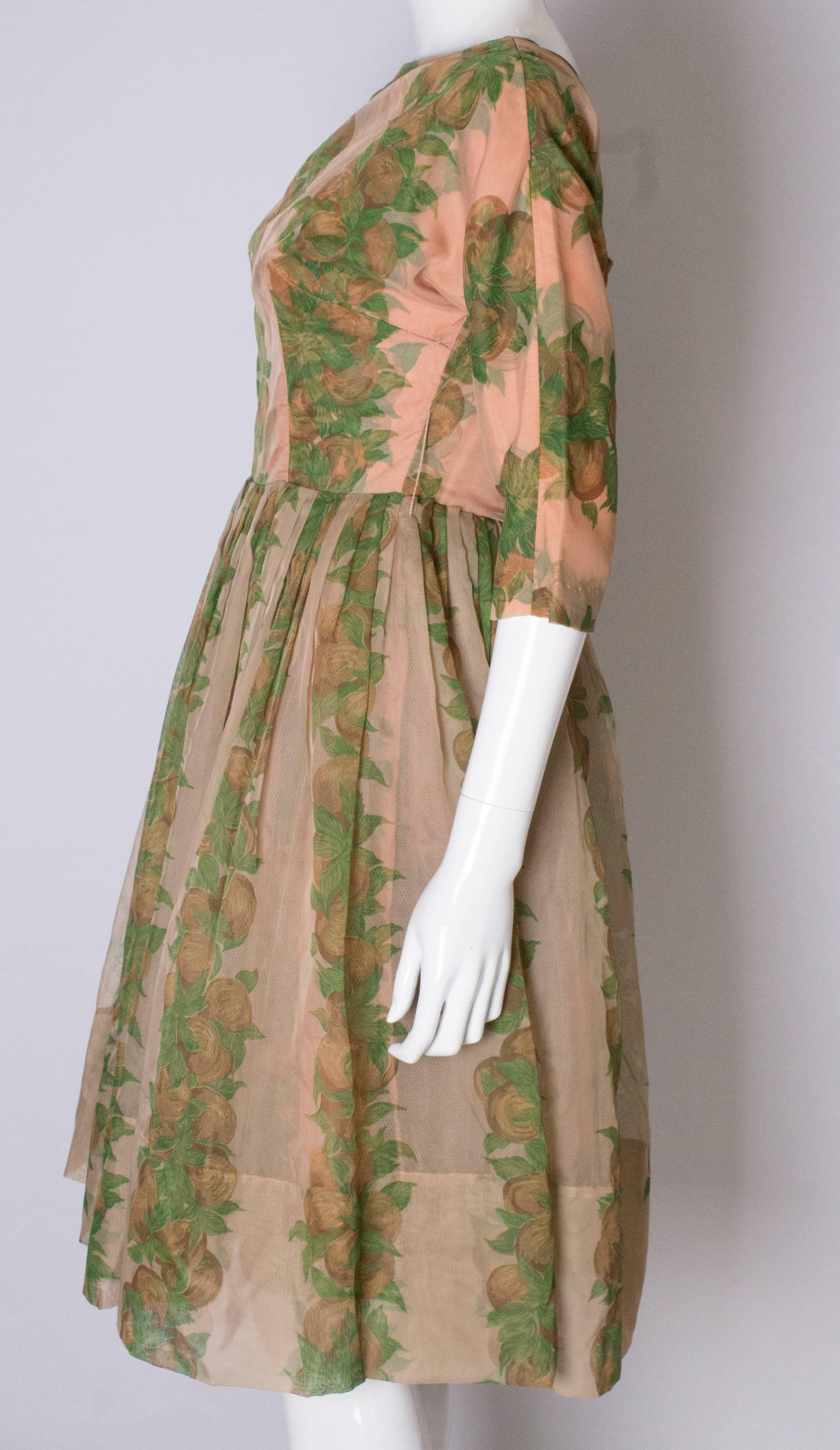 A Vintage 1950s Apricot, Green and Brown print swing cinch party dress 2