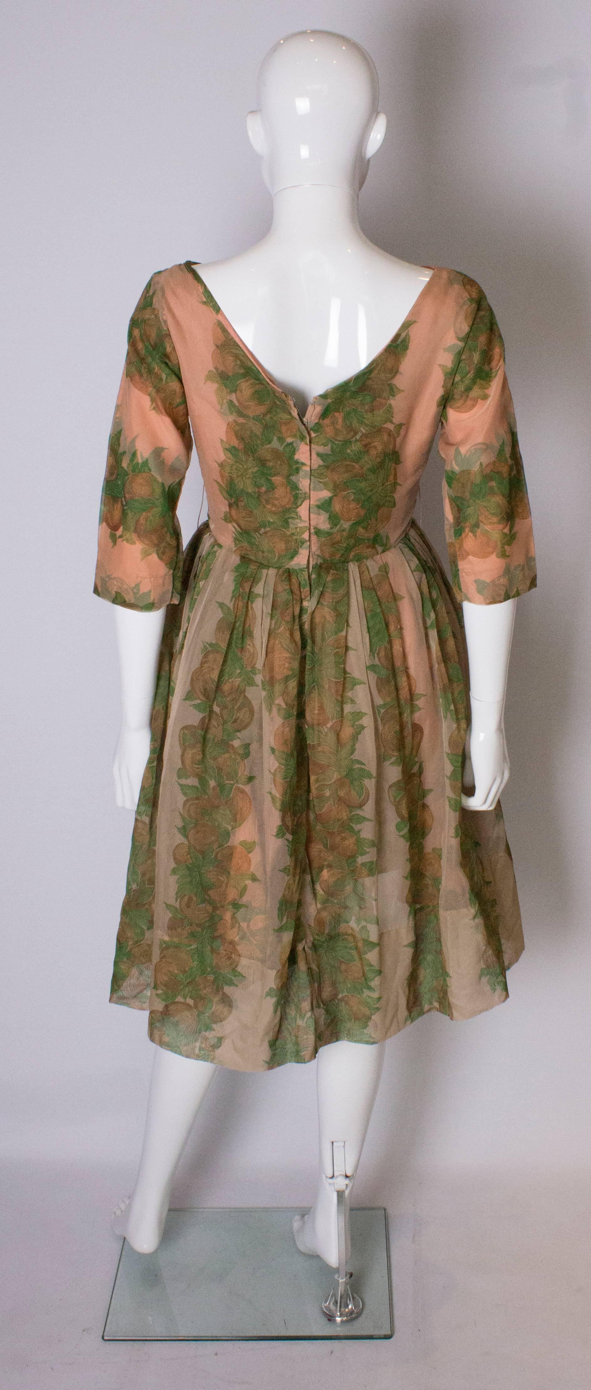 A Vintage 1950s Apricot, Green and Brown print swing cinch party dress 3