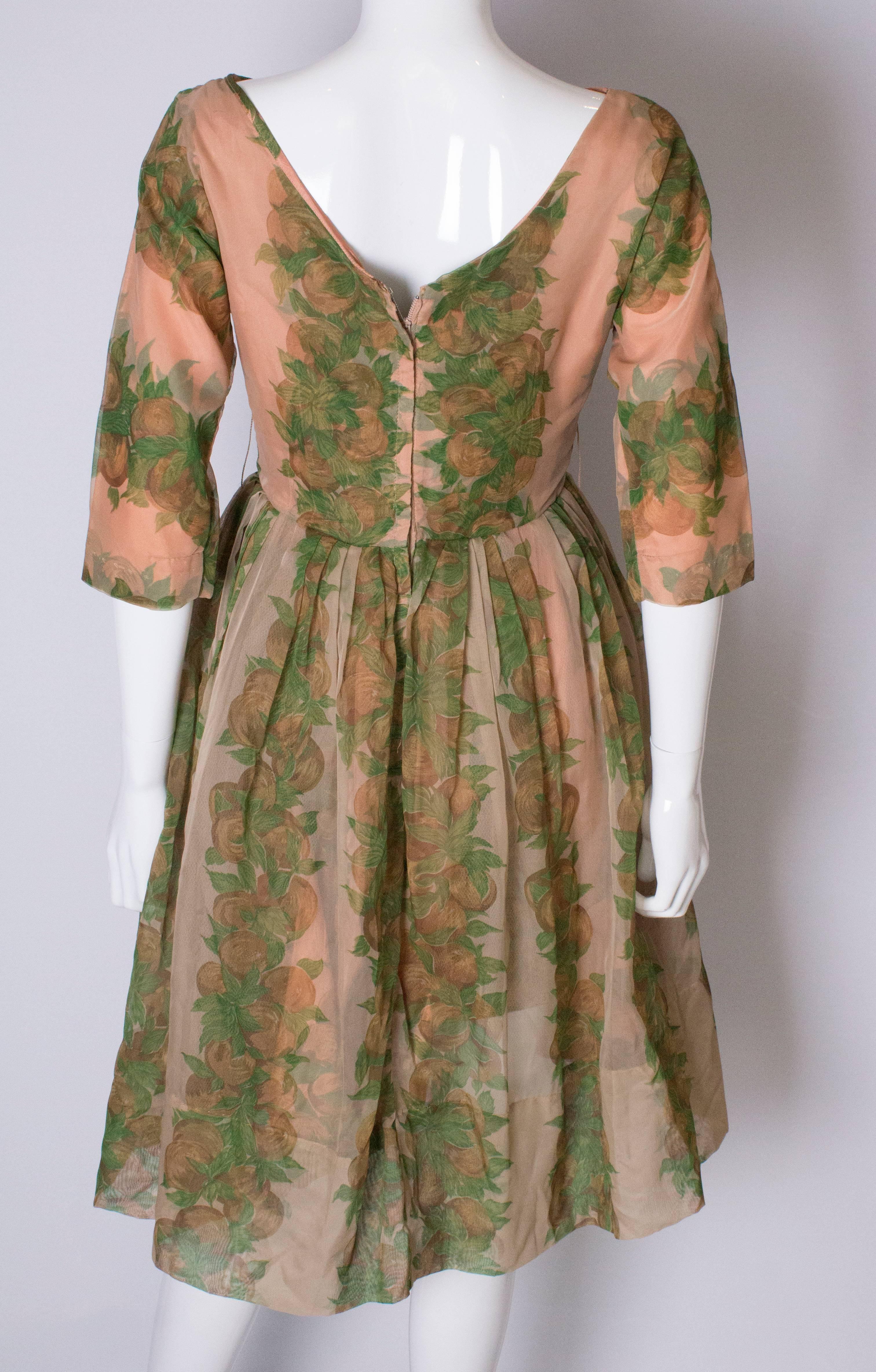 A Vintage 1950s Apricot, Green and Brown print swing cinch party dress 4