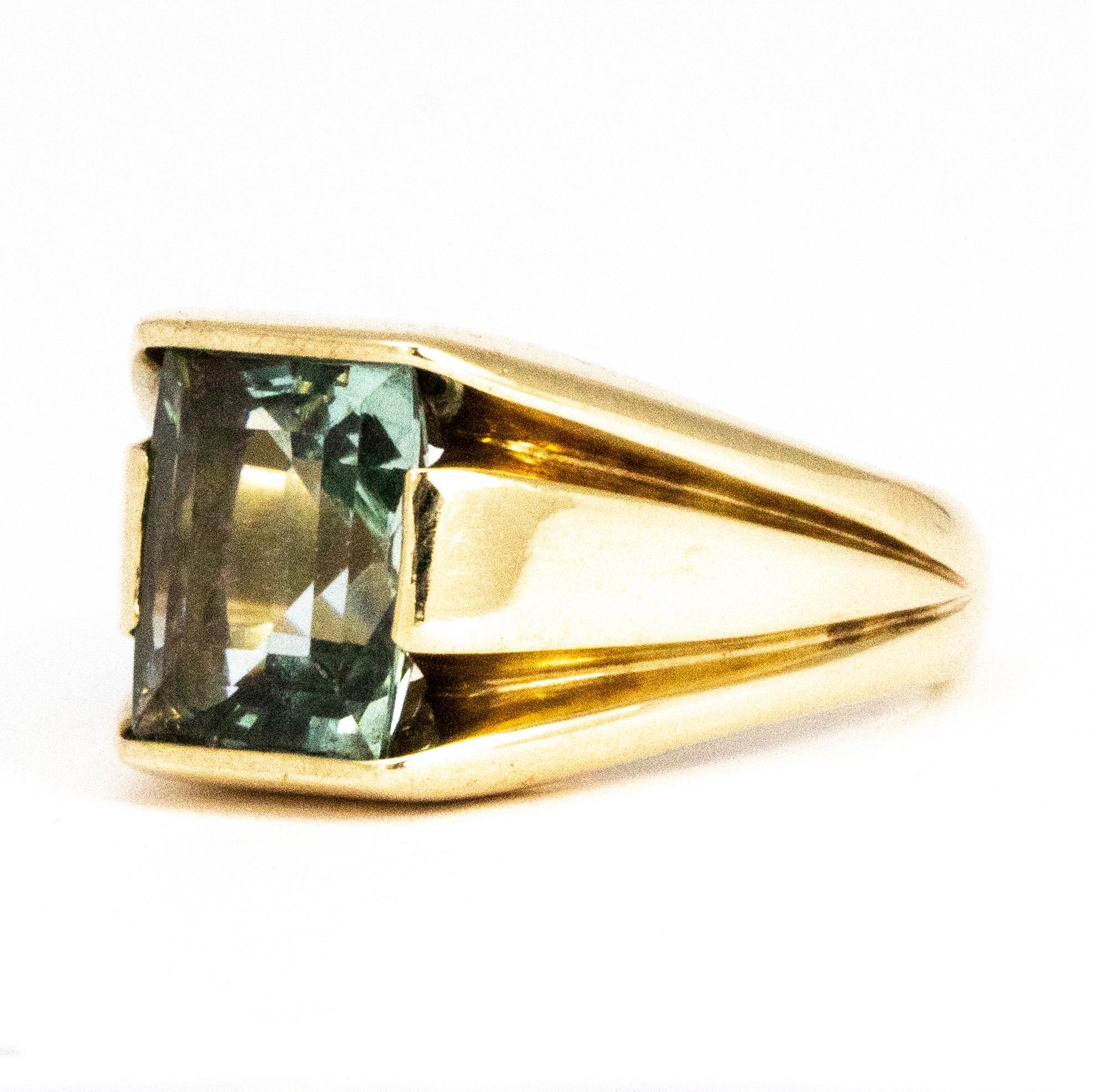 At the centre of this gorgeously chunky gold band is a stunning aqua stone. The light reflects beautifully off the aqua stone and the blue is pale and soft. The grooves either side of the band give this ring an ultra modern look. 

Ring Size: M 1/2