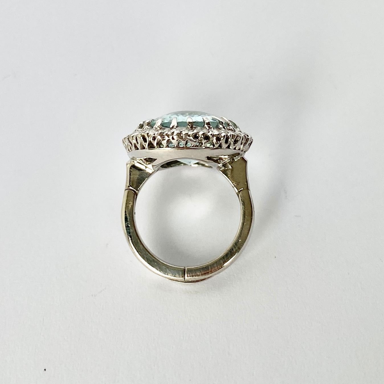 Sitting proud at the centre of this wonderful cluster ring is a sparkling aqua stone measuring approx 9carat. Around the aqua stone sits a halo of smaller diamonds totalling 1carat. The band does have an opening arthritic band but can be replaced
