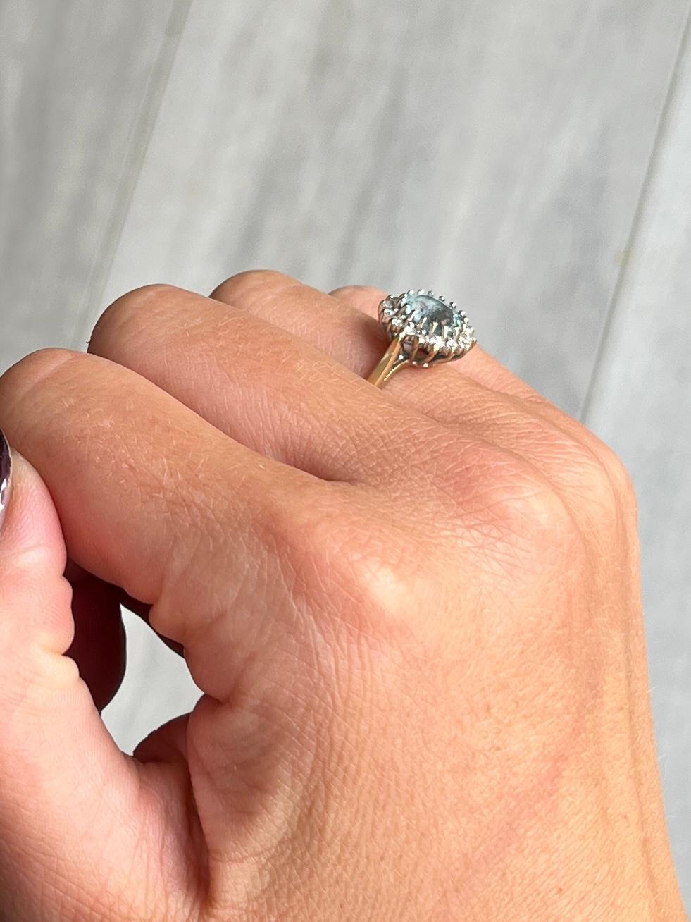 Sitting proud at the centre of this wonderful cluster ring is a sparkling aqua stone. Around the 1ct aqua stone sit a halo of smaller diamonds each measuring approximately 2pts each. All sit on an open work setting with simple shoulders. Hallmarked