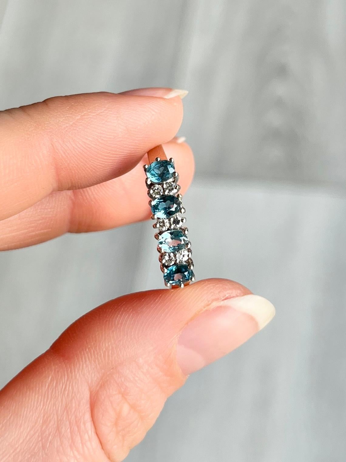 This ring holds four aqua stones measuring 60pts in total and in-between these beautiful blue stones are pairs of diamonds measuring 2pts each. Modelled in 9carat gold and hallmarked London 1988.

Ring Size: V or 10 1/2 
Width: 4.5mm

Weight: 2.7g