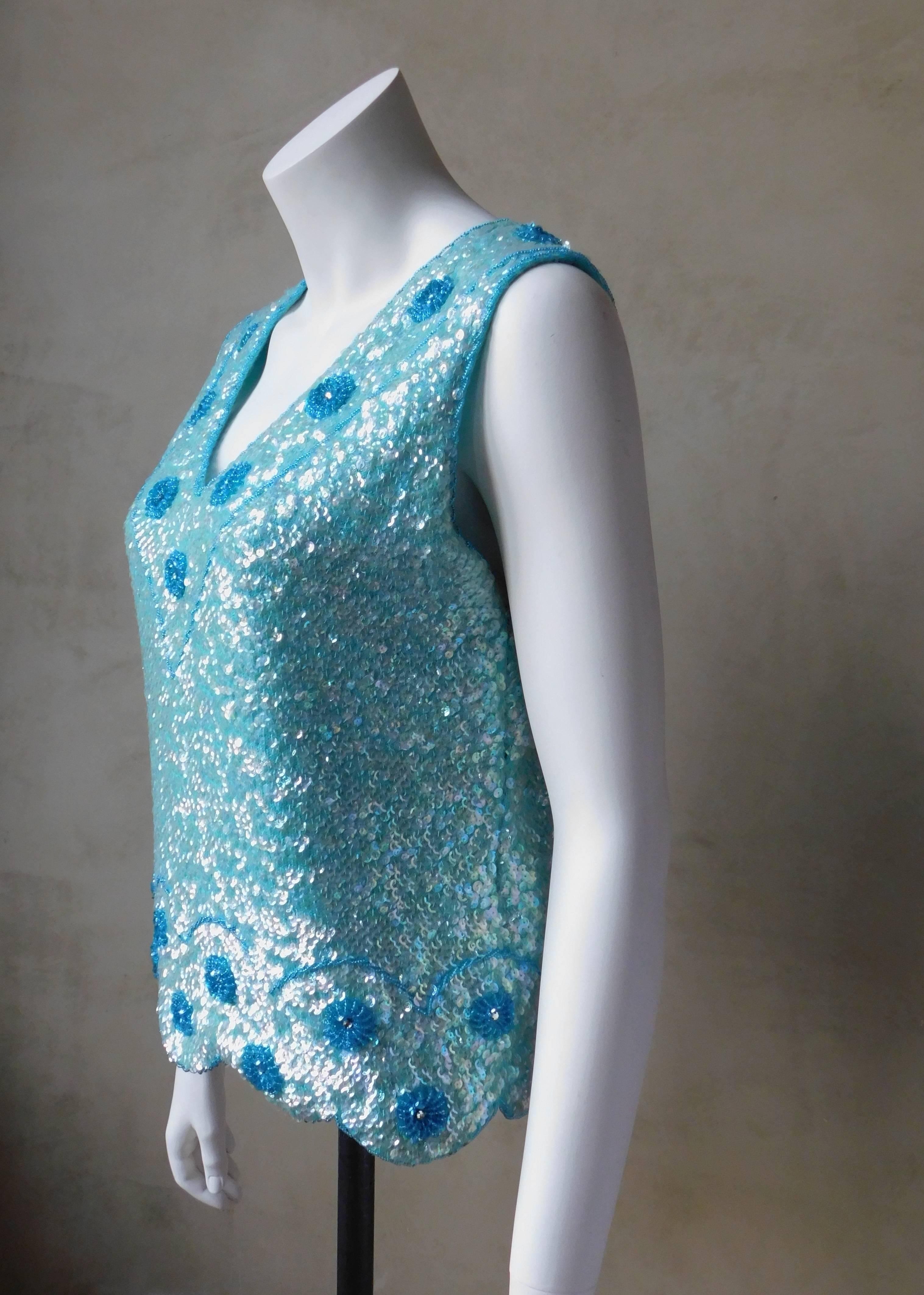This vintage  1960's cashmere sweater is fully encrusted with opaline sequins giving the surface a mermaid affect. The neckline and scalloped bottom edge have hand beaded flowers. Absolutely rare to find a sweater of this vintage in such good