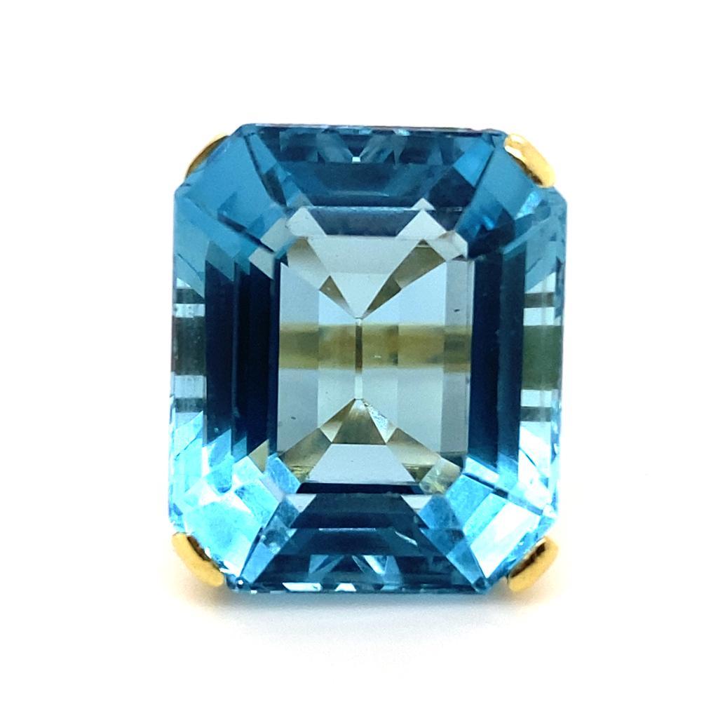 A vintage aquamarine 18 karat yellow gold cocktail ring, circa 1960.

This ring is set with an impressive emerald cut aquamarine of 35.88cts approximately in a claw setting leading to plain polished yellow gold shoulders.

The simple design of this