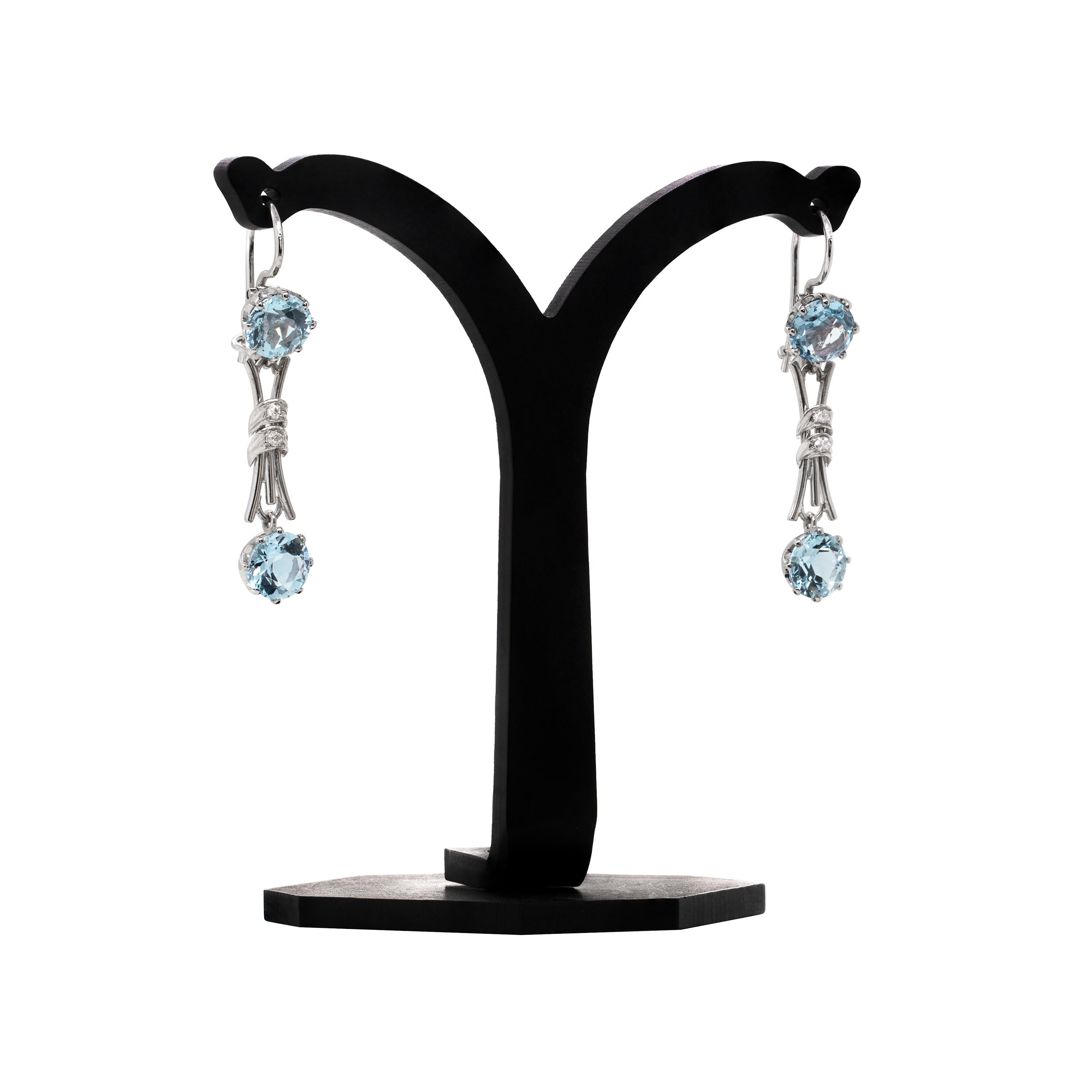 These delicate drop earrings feature two beautiful round shaped aquamarines in each, with a total approximate weight of 2.40ct, mounted in eight claw open back settings. The two aquamarines are connected by fine white gold curved bars tight in the
