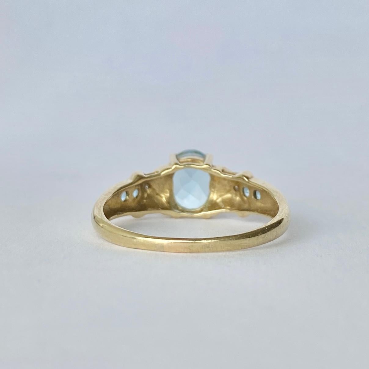 This stunning ring holds a gorgeous pale blue aqua at the centre measuring 1carat and the shoulders also hold two round aquamarine stones each totalling 10pts per shoulder. Either side of the central stone there are two 'kisses' that hold a diamond