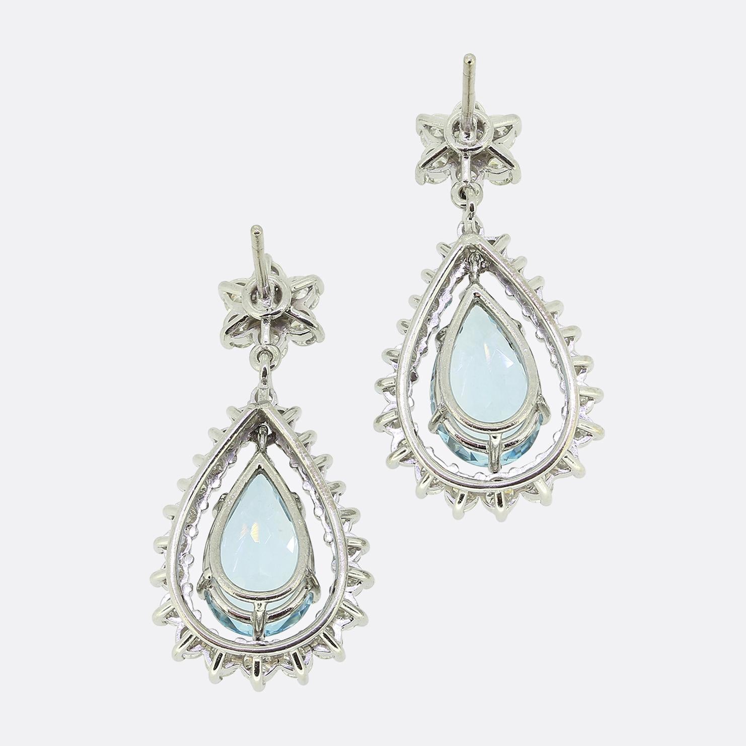 Here we have a gorgeous pair of drop earrings. Each vintage piece showcases a single sizeable pear shaped aquamarine which swings freely amidst a frame of round brilliant cut diamonds which graduate in size from top to bottom. This scintillating