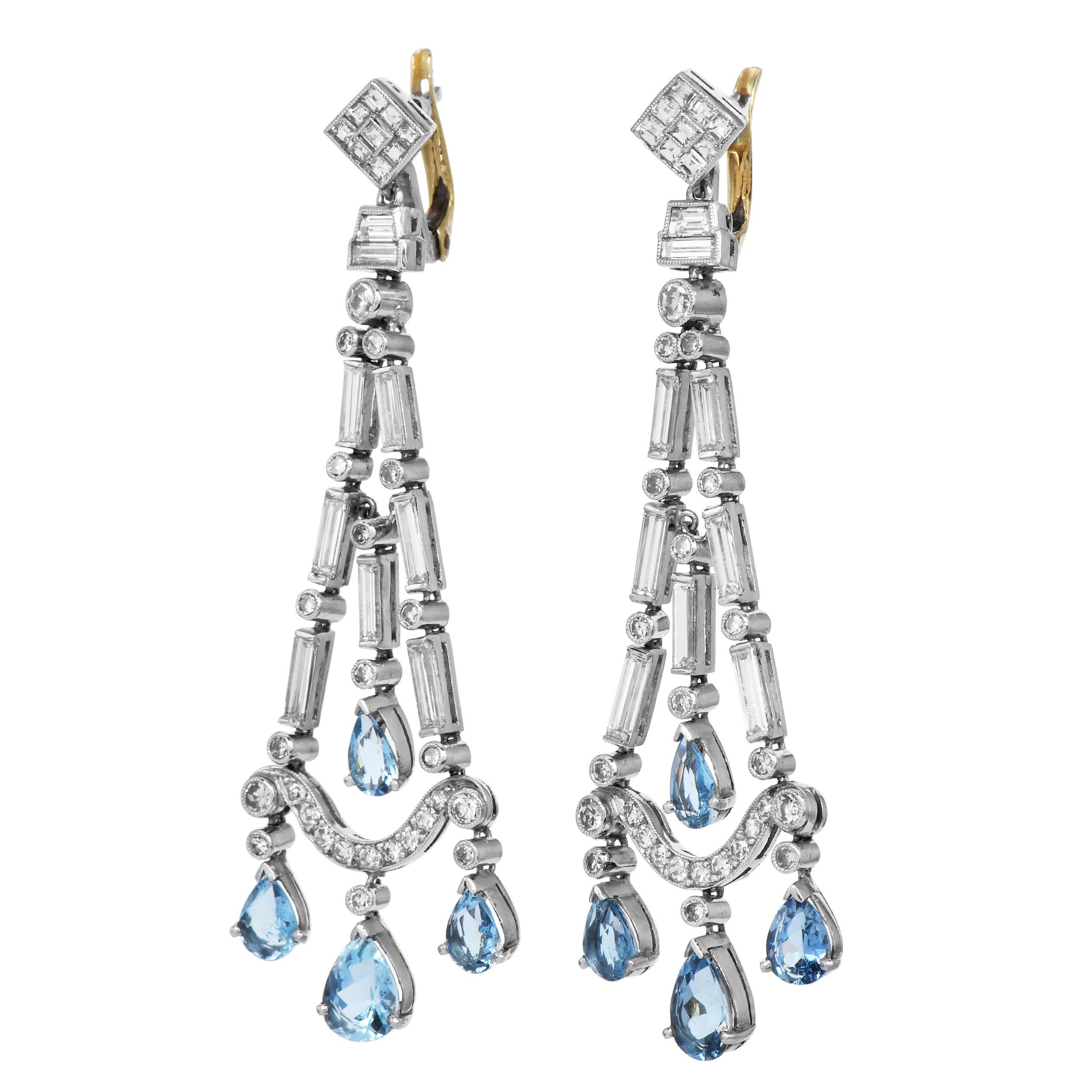 Questi straordinari orecchini a lampadario mostrano l'eleganza senza tempo del design Art Deco, con gemme vibranti. Realizzati in platino con chiusura a leva in oro giallo 18 carati, gli orecchini presentano una cascata di diamanti e acquamarine