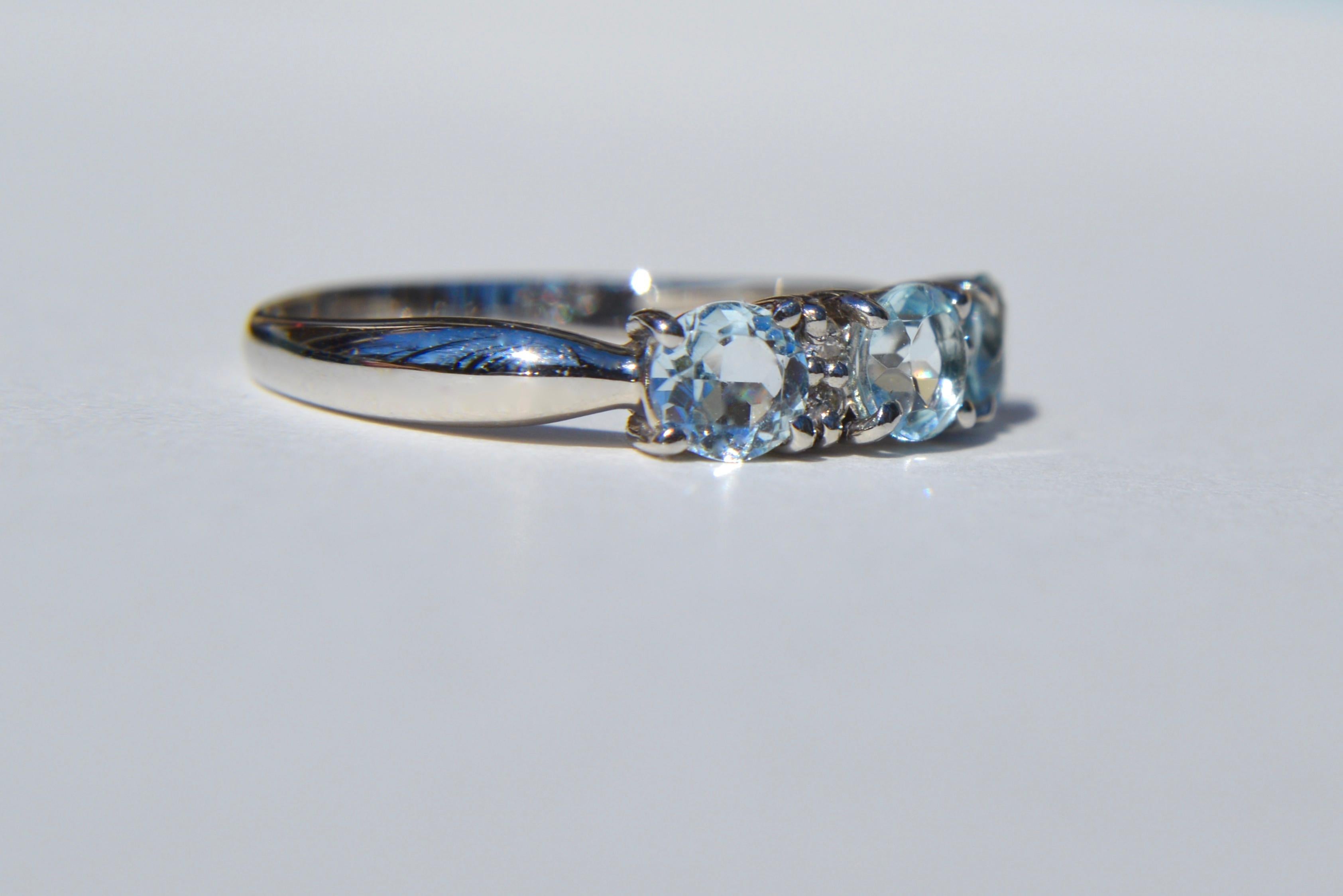 Lovely vintage midcentury circa 1960s natural aquamarine and diamond trinity trilogy ring in solid platinum. Marked PT900 for platinum. Size 6.25, can be resized by a jeweler. Each round cut high quality aquamarine measures 4mm in diameter, .25