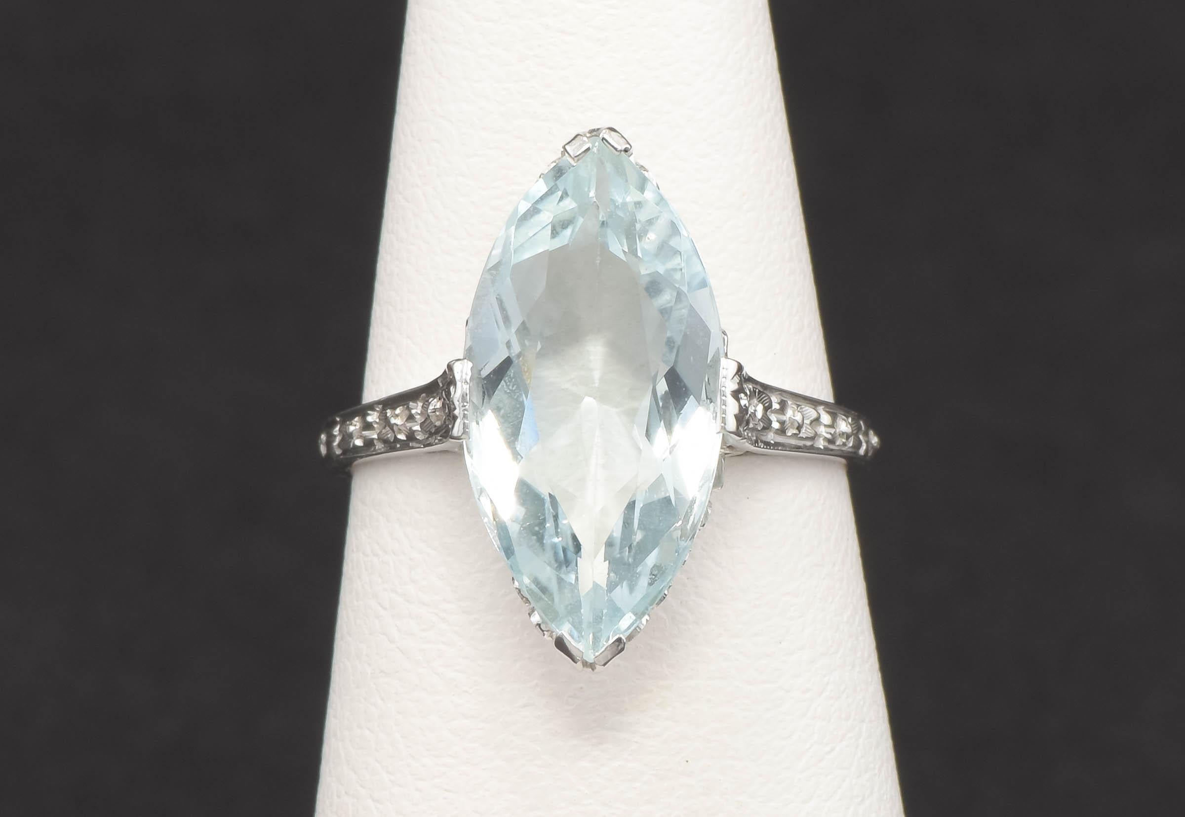 Elegant flower blossoms and unusually pretty filigree. set off the lovely Aquamarine in this ring.  While Edwardian to Art Deco in style, I believe it was likely made later, from the 1940's to 1950's.

Crafted of 18K white gold, the ring features a