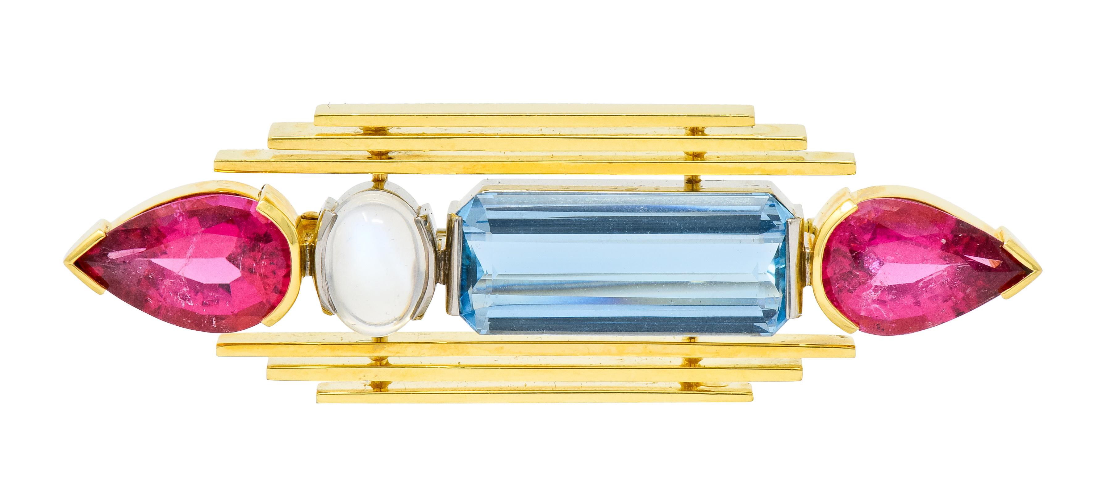 Bar style brooch centering a row of playfully colored and shaped gemstones, flanked by polished gold striations

Terminating as two pear shaped tourmaline measuring approximately 11.0 x 7.5 mm, very well-matched and extraordinarily pink in
