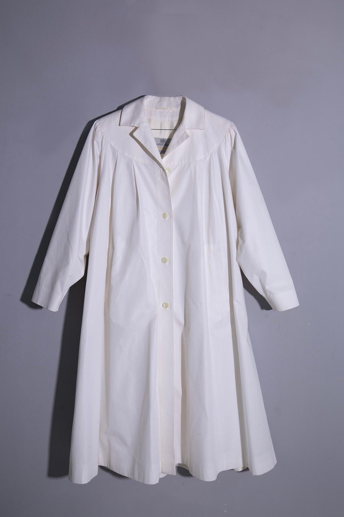 Der Damen-Regenmantel AQUASCUTUM 5 aus den 1980er bis frühen 1990er Jahren ist ein zeitloses Stück, das mühelos Stil und Funktionalität vereint. Dieser Regenmantel aus weißem Acetat strahlt Raffinesse und Eleganz aus und bietet gleichzeitig Schutz