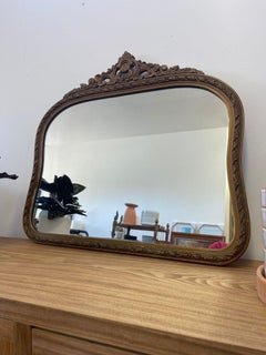 Specchio d'epoca con cornice in legno dorato e intagliato ad arco. Circa anni '1940