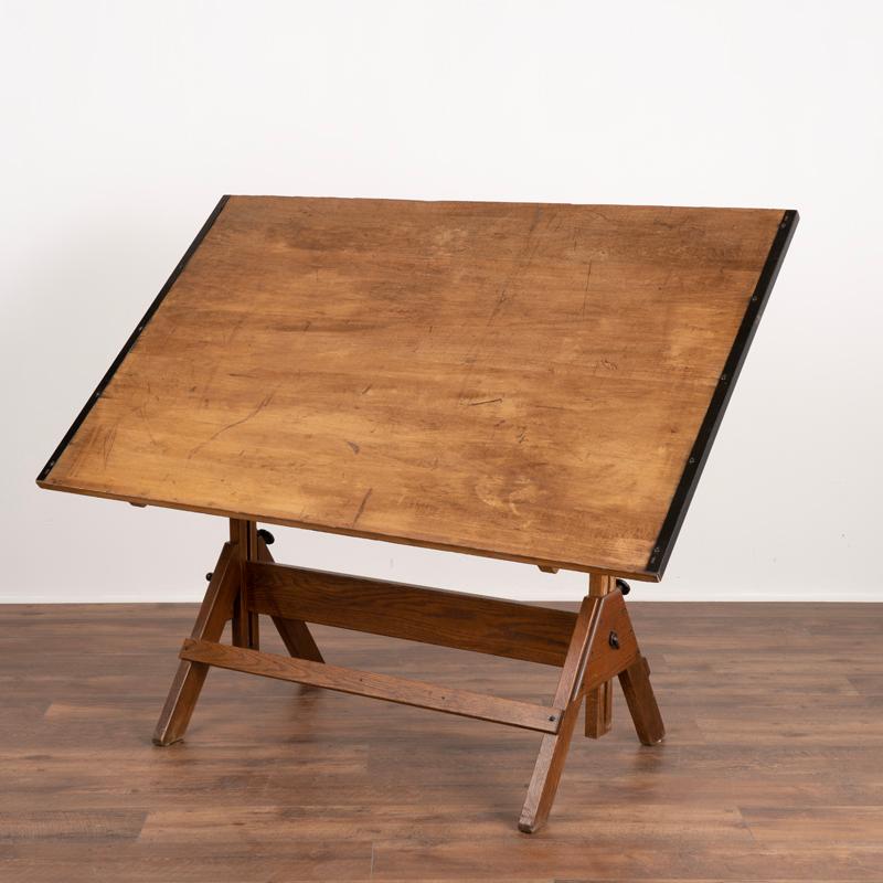 Vintage metal and wood architect's or drafting table. The attractive wooden top has a traditional adjustable inclination system. This Industrial style will look and serve well in today's modern home. Any nicks, scratches, or signs of wear and