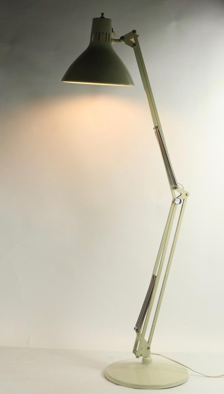 Articulating angle poise desk lamp after George Carwardine, in original off white finish. The lamp can flex up and down, pivot on the base, and the hood shade also can pivot and tilt to direct the light. This example is in extra clean, working
(UL