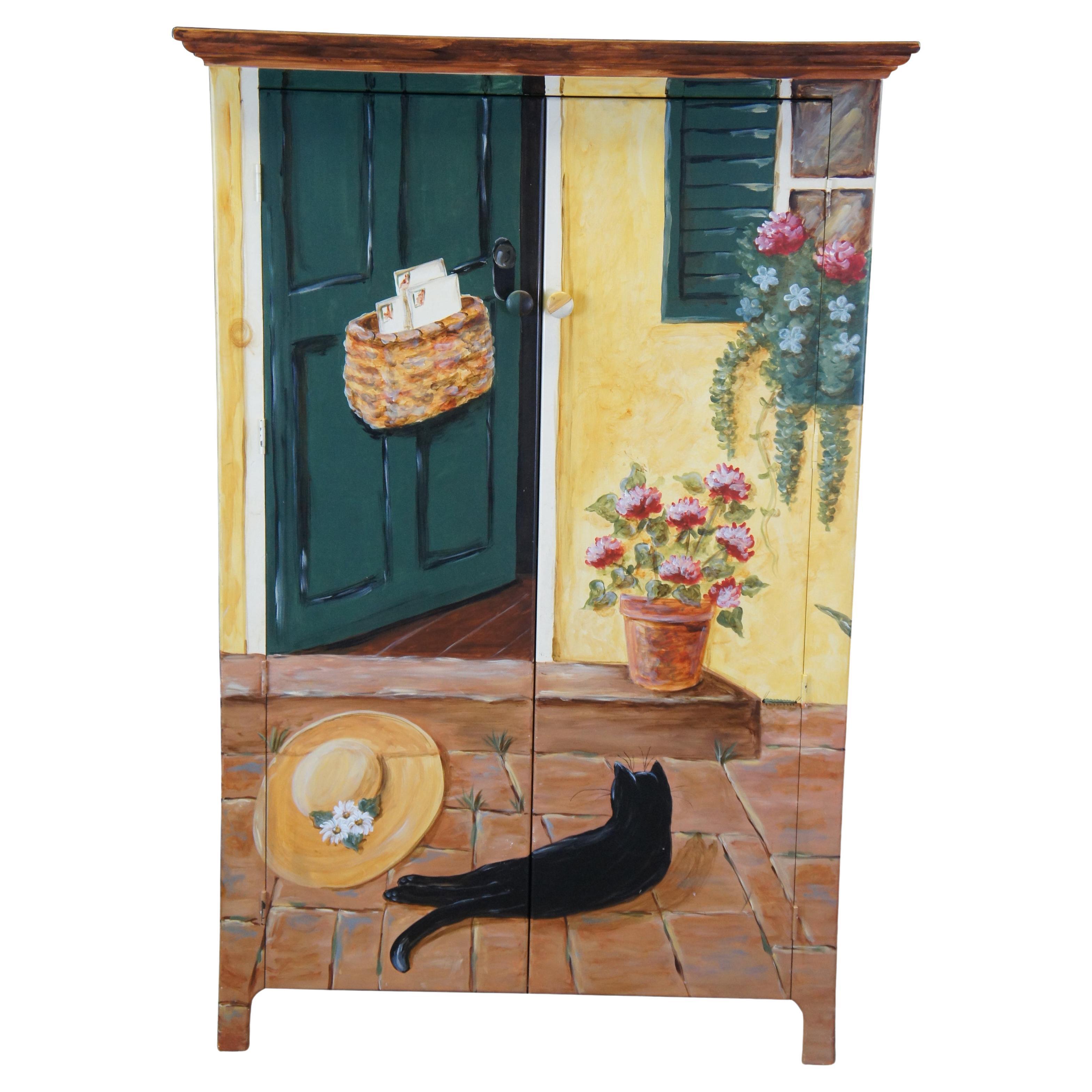 Vintage Arhaus Camden Field Collection armoire, cabinet or linen press featuring a painted farmhouse cottage scene with an open door, blooming flowers, and lounging black cat sunbathing on the bricks of the stoop next to the gardeners hat. circa