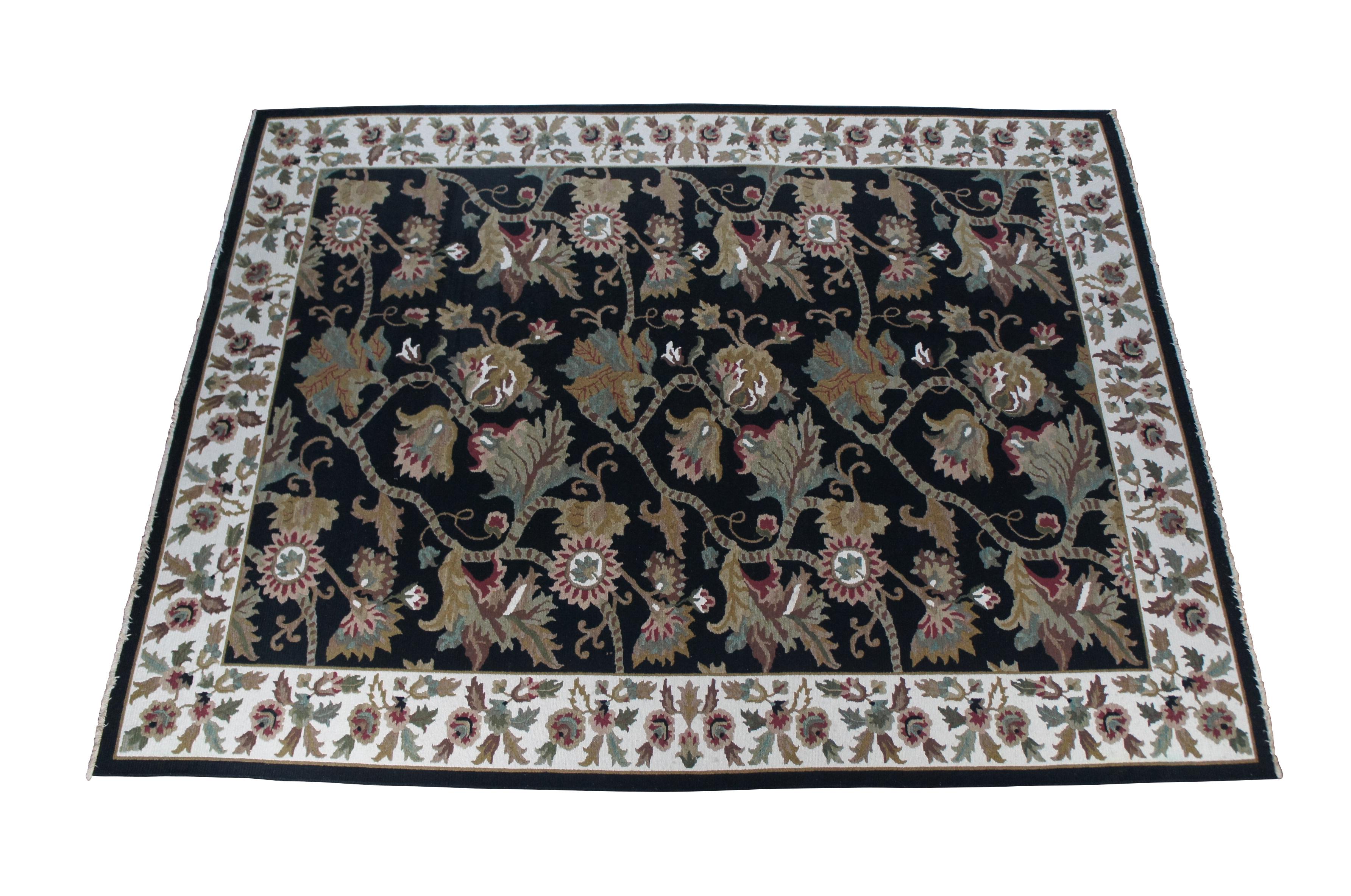 Vintage Arhaus Oriental rug.  Made of wool featuring a hand knotted floral all over design with flowers, vines and acanthus designs.

Deep blue / black field with greens, tans, reds, pinks, browns, creme / beige.  Made in India.   MSRP