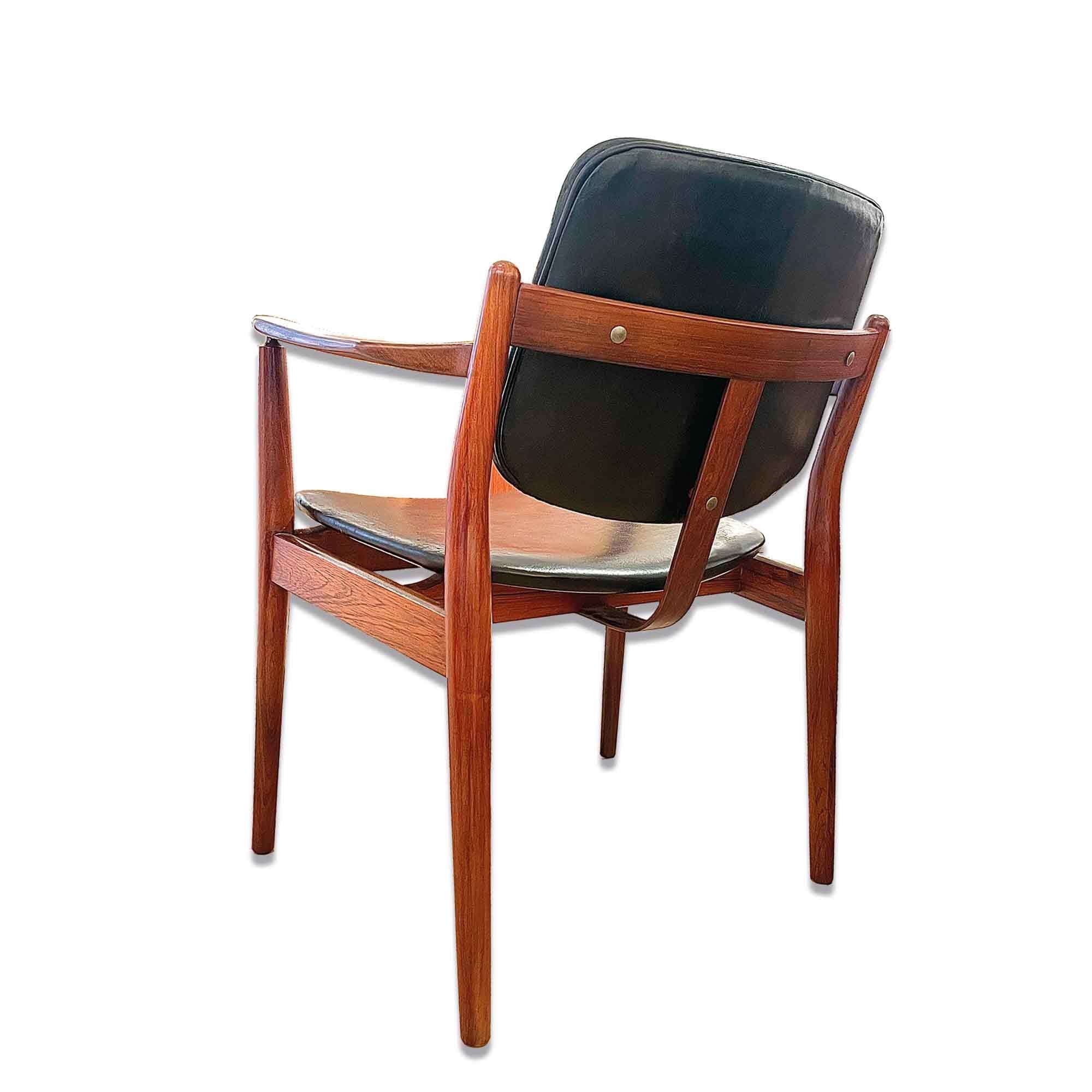 Rosewood armchair by the great Danish designer Arne Vodder. The clean lines and minimalist details of this armchair make it an elegant and timeless choice. Rosewood provides natural warmth, plus its veining is very remarkable. The Scandinavian