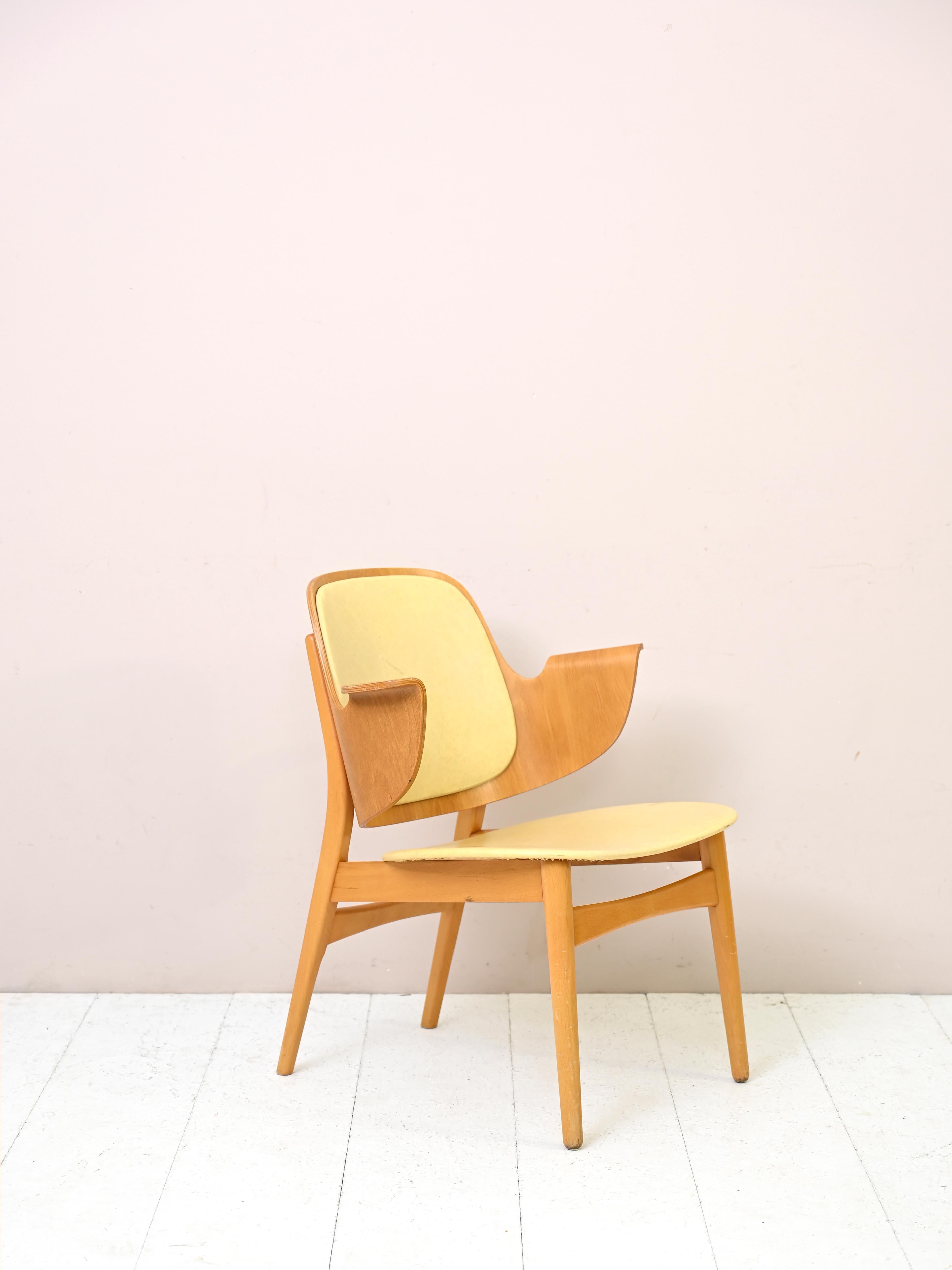 Vintage model 107 armchair designed by Danish designer Hans Olsen.
A classic Danish design: the backrest and arms are on a single piece of shaped laminated wood.
The seat and back are upholstered in yellow leatherette.

Pair of model 107 shell