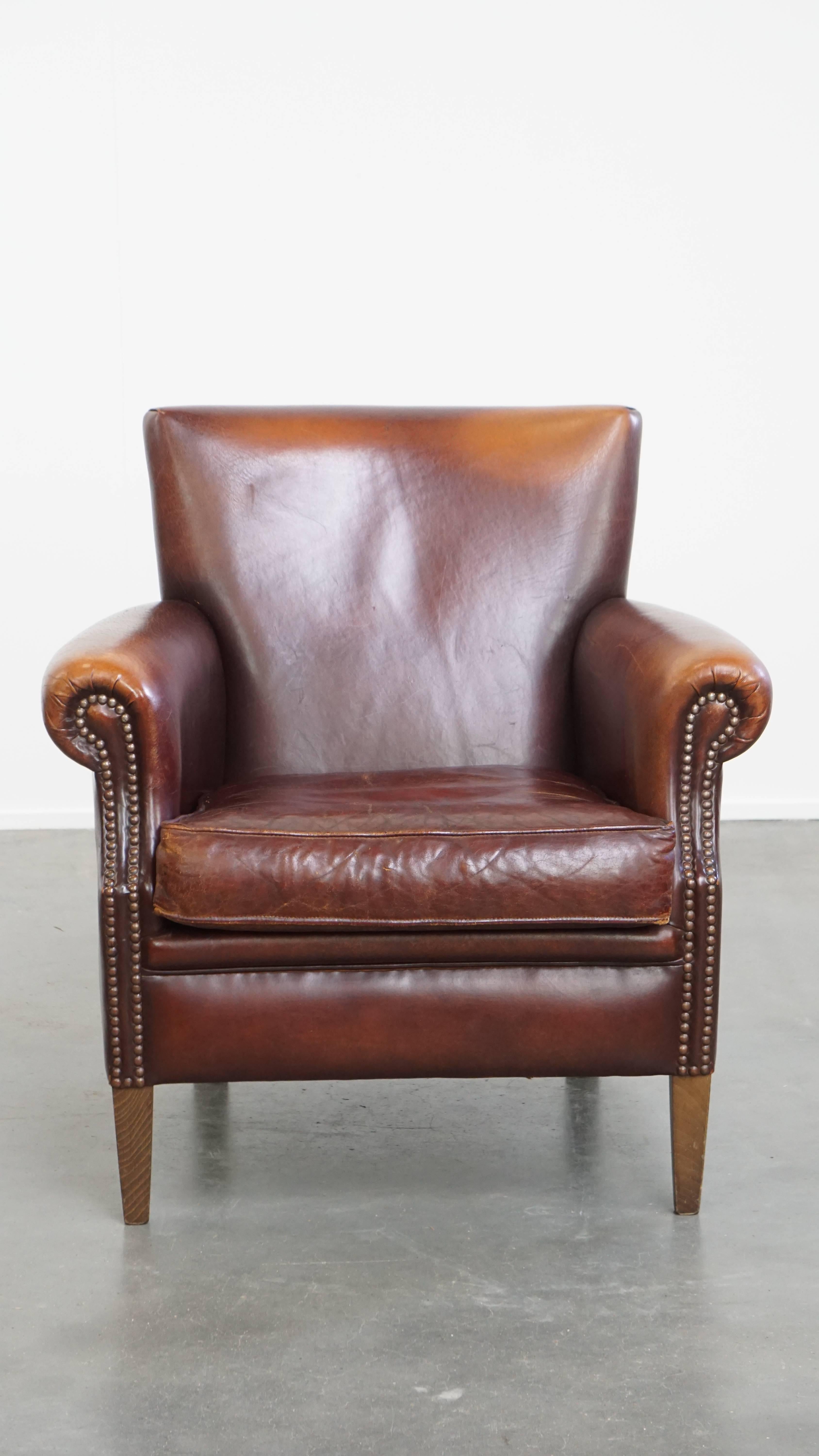 Nous vous proposons ce fauteuil vintage de caractère en cuir de mouton avec une belle palette de couleurs chaudes. Au fil des années, ce charmant fauteuil vintage a développé une merveilleuse patine. Ses tons chauds lui confèrent un aspect douillet