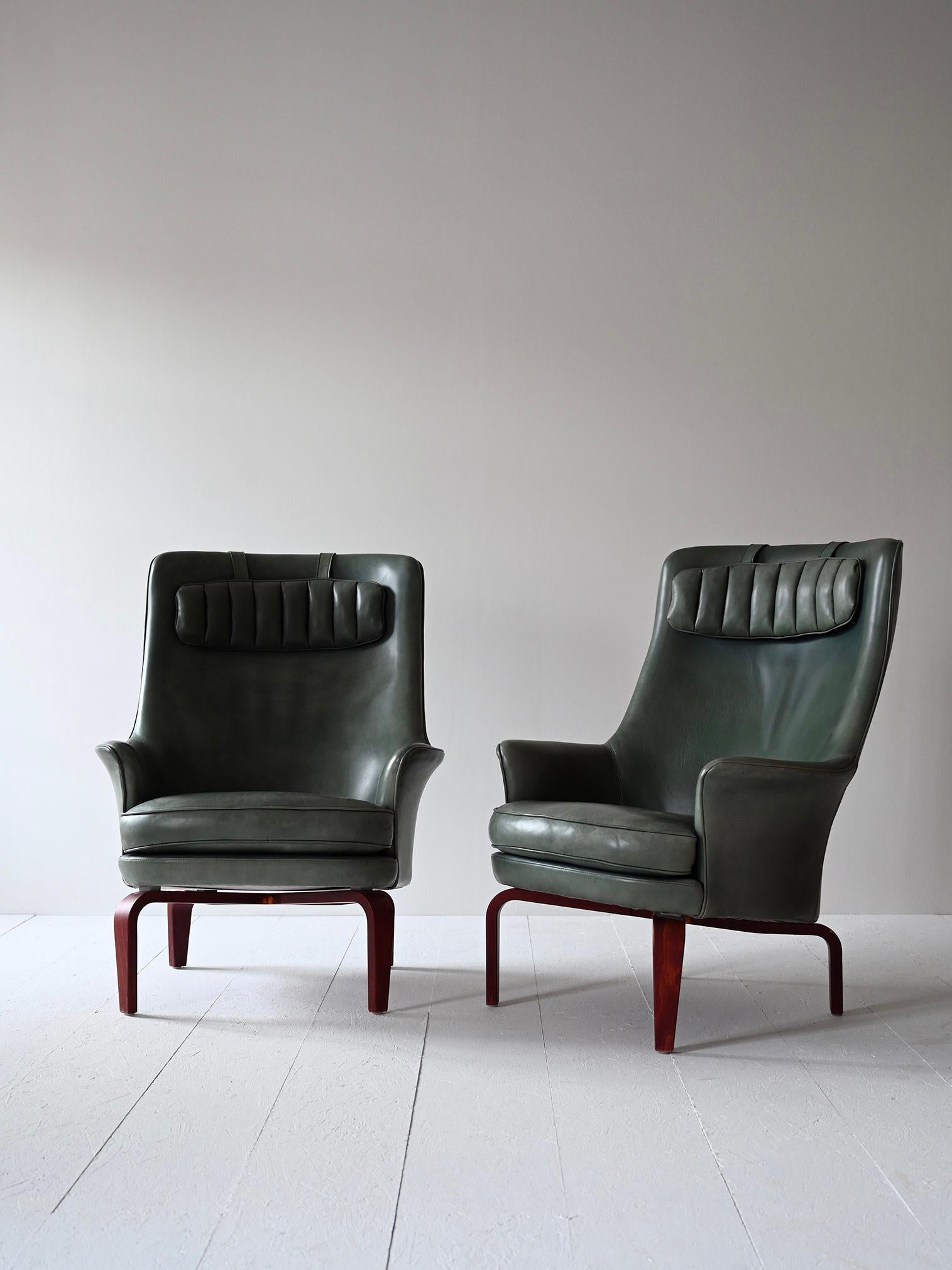 Pair of Pilot model chairs designed by Swedish designer Arne Norell in 1967. 

Consisting of an upholstered frame covered in sage green leather and beechwood legs.
A distinctive feature of these chairs is the slight elevation of the front frame, an