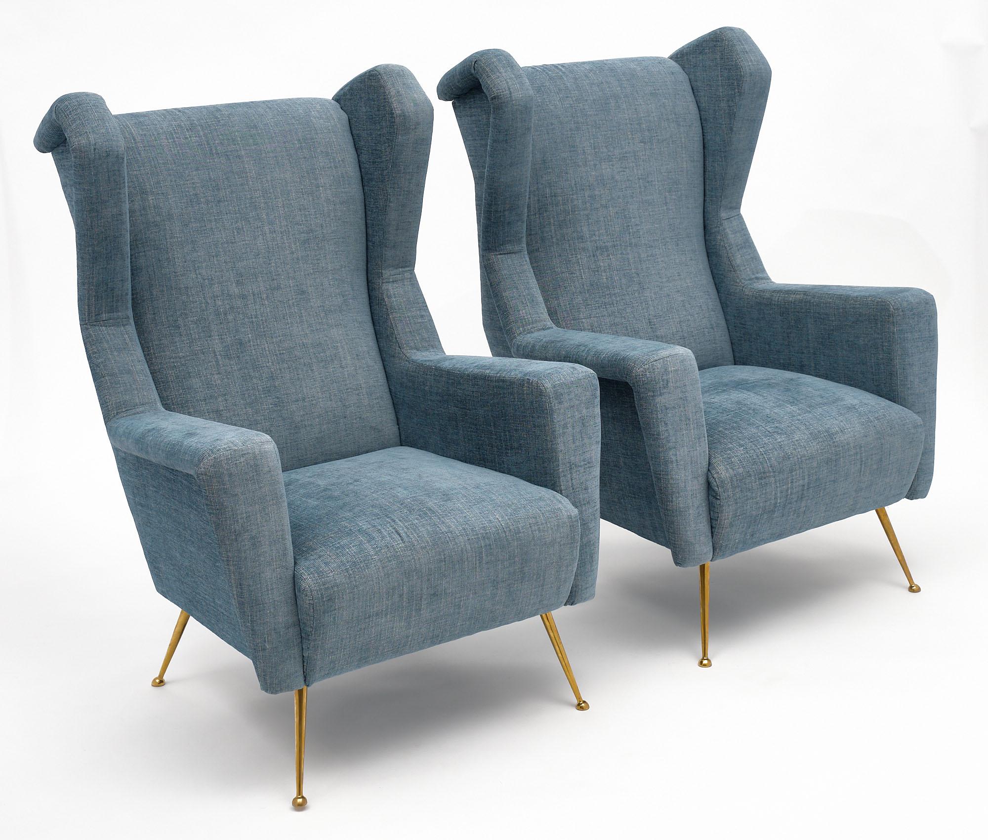 Pair of vintage armchairs or “bergeres” in the style of Carlo di Carli. They have been newly upholstered in a blue wool blend mix. We are drawn to the solid gilt brass legs and strong proportions of this pair.
