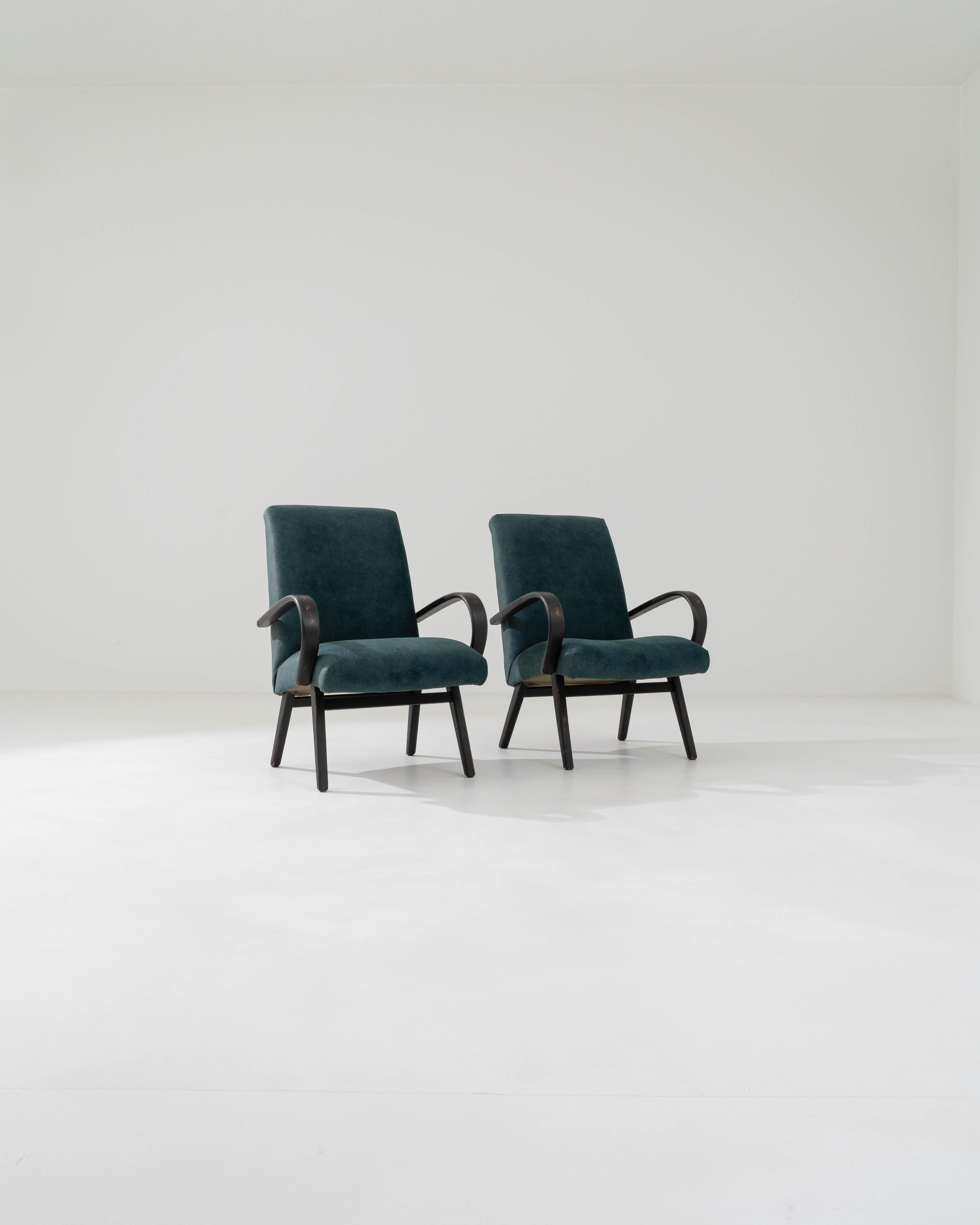 A piece from J. Halabala, a top mind who played a pivotal role in the design industry in the Eastern Bloc. This pair of highly collectible armchairs are upholstered in a beautiful velvet that iridescences from light to dark blue with a distinctive