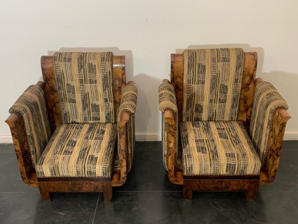 Paar ausgestellte Kelch- oder Leier-Sessel in ausgesuchtem Nussbaumwurzelholz. Die Linien erinnern an die Entwürfe von Franco Albini, die Stoffe sind im Bauhaus-Stil gehalten. Die Sessel sind auf 1925/30 zu datieren. Das Sofa, das zu den Sesseln auf