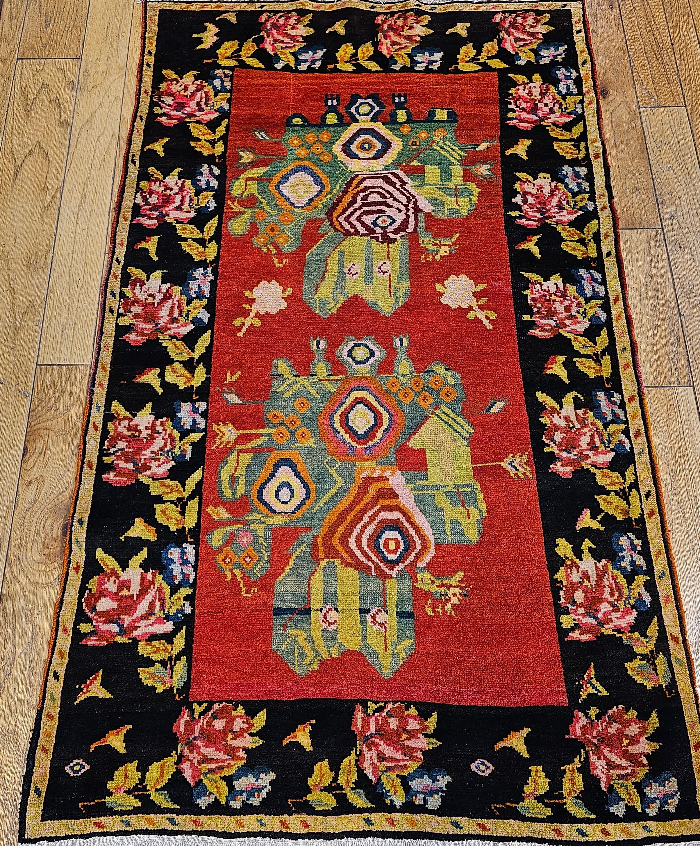 Vintage Karabagh area rug from the Armenian village weavers of the Caucasus mountains comes in a beautiful floral pattern in red, pin, green, yellow and blue .  The use of the brilliant red color in the field and the “impression” of a flower vase
