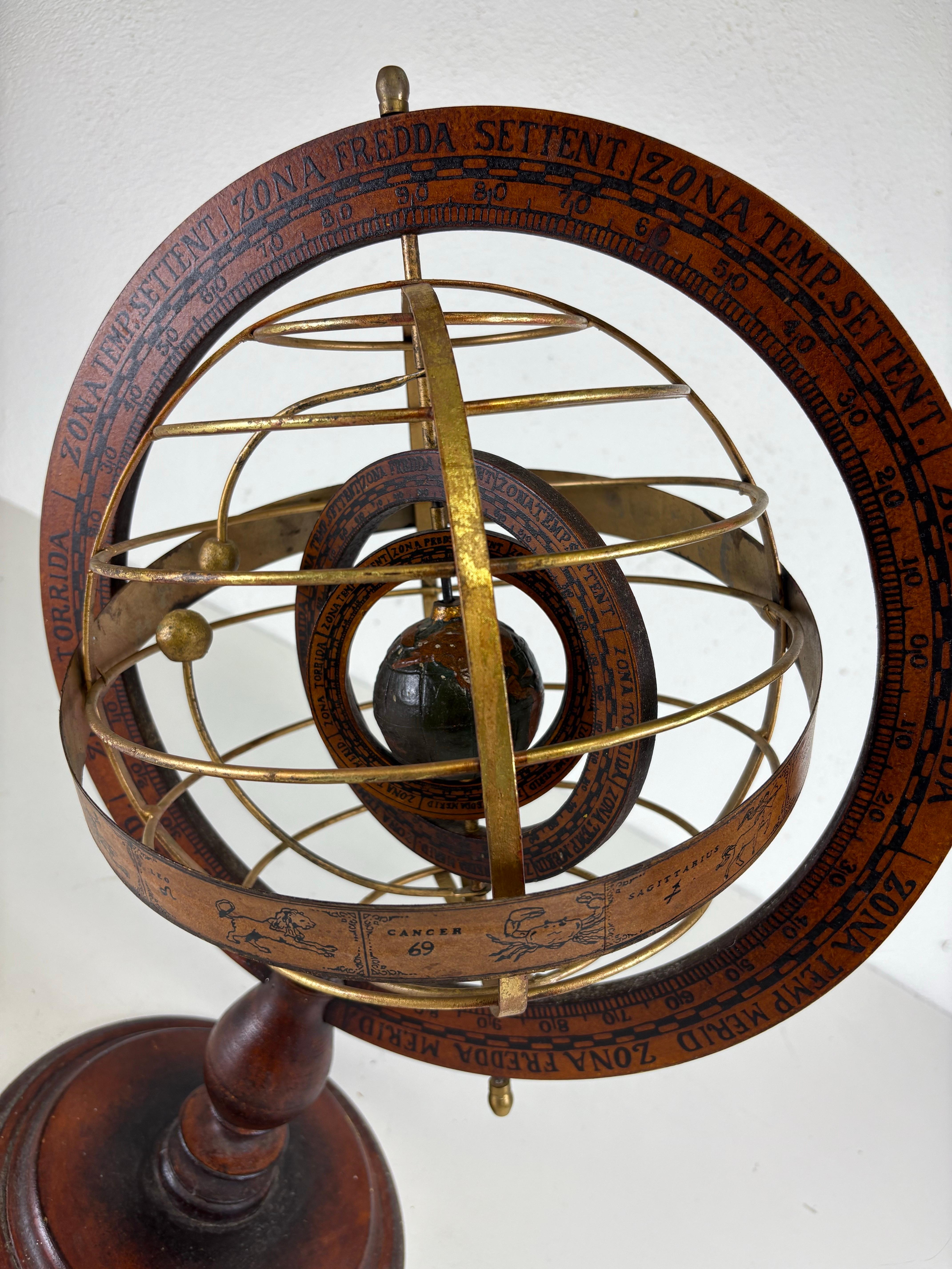 Si tratta di un globo o sfera armillare d'epoca. Il mappamondo scultoreo è composto da anelli di metallo e legno con raffigurazioni dei segni zodiacali dipinte sulla parte in legno. Gli anelli del mappamondo sono dorati con una cornice in legno