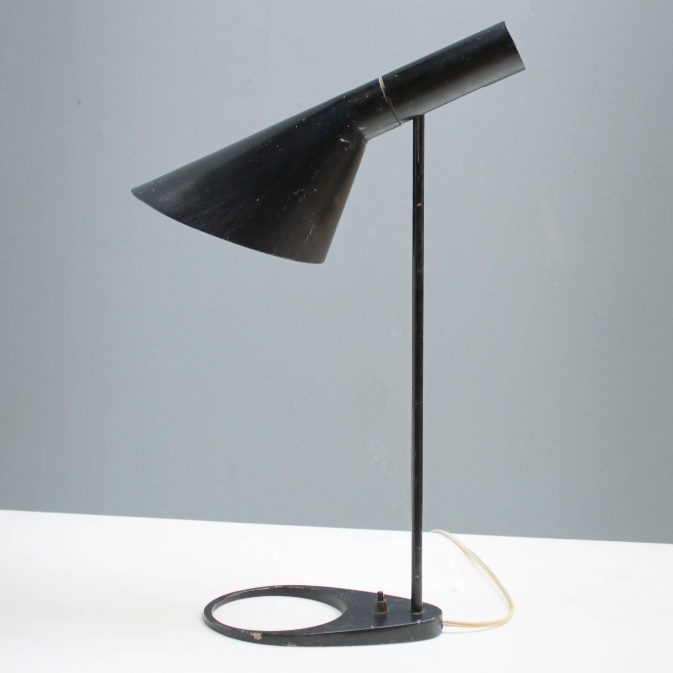 Original first edition Arne Jacobsen AJ table lamp for Louis Poulsen. The AJ lamps were designed in 1957 by Arne Jacobsen for the SAS Royal Hotel in Copenhagen.
Dimensions: max height 21.6 in. (55 cm), length shade 13.4 in. (34 cm), diameter shade