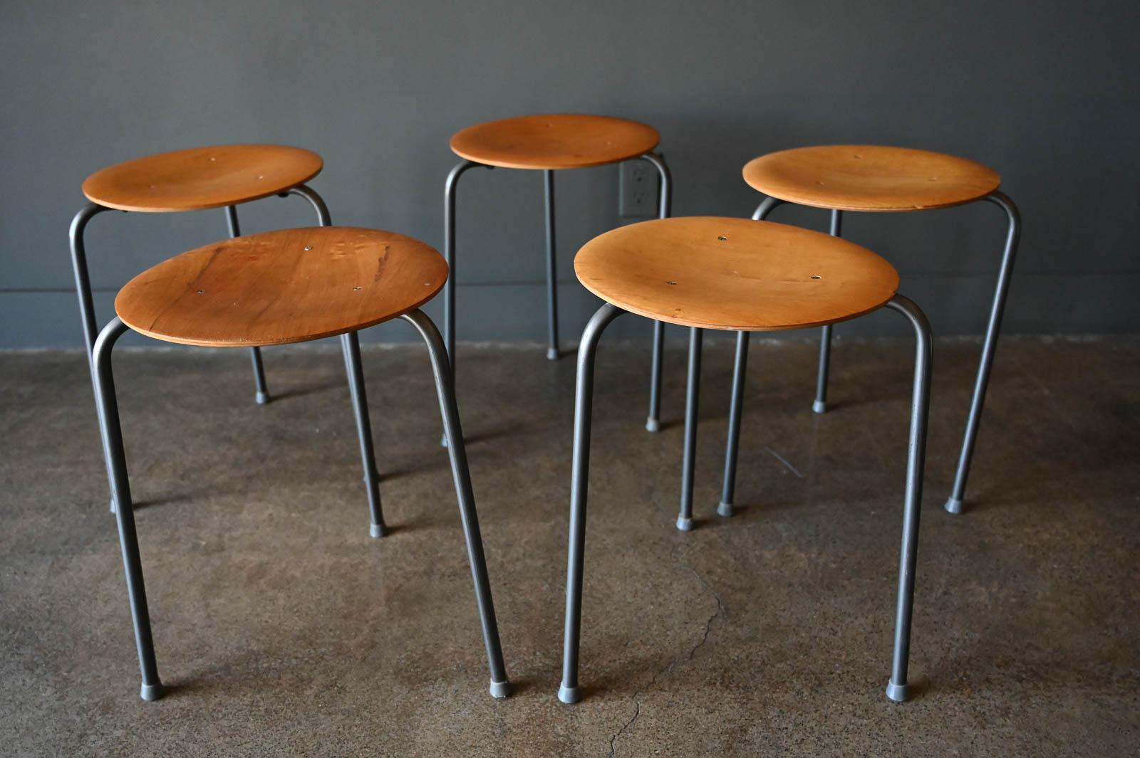 Vintage Arne Jacobsen dot stools in teak, circa 1960. Sold individually, good condition with grey leg finish and floor protectors. Stamped on underside. Measures 12