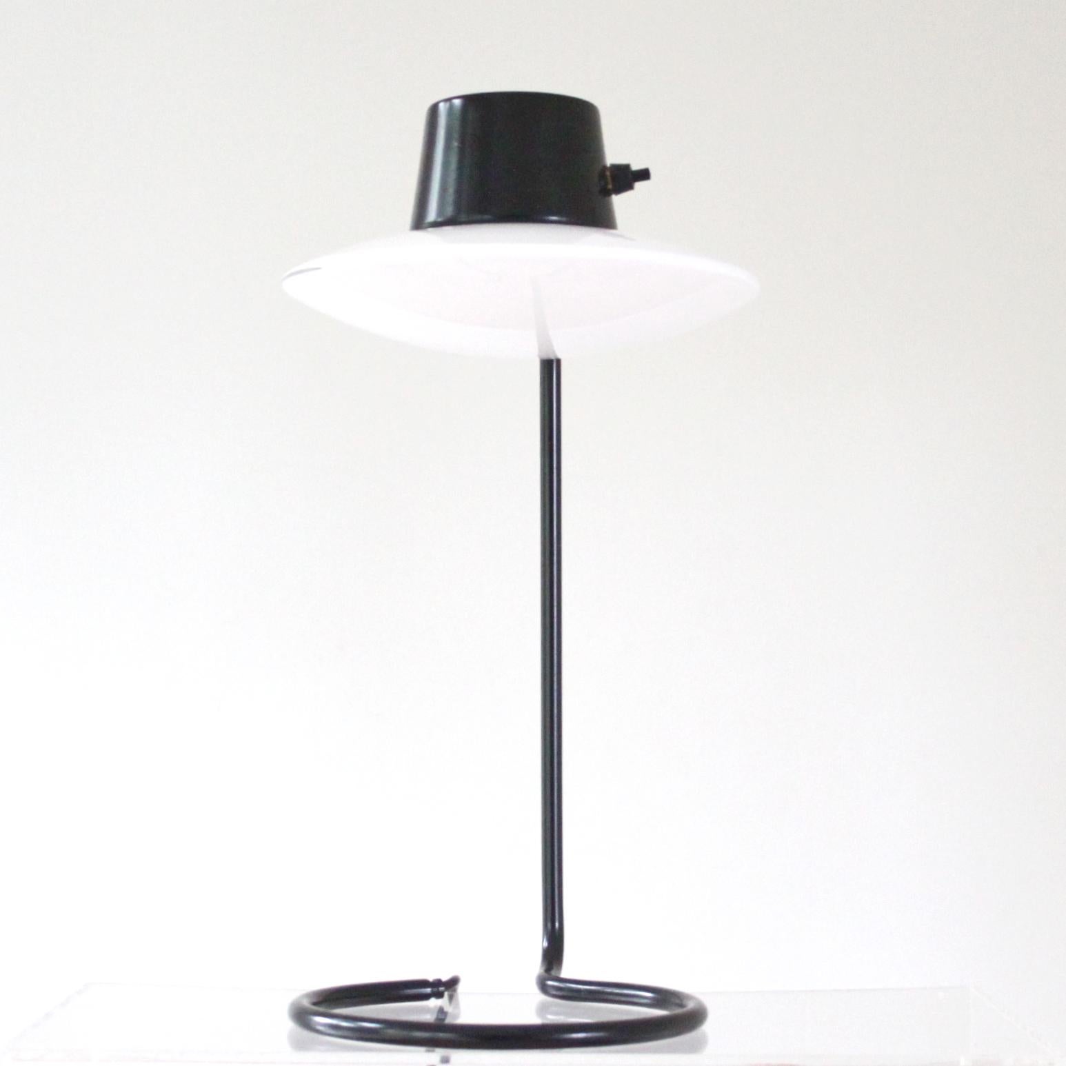 ARNE JACOBSEN & LOUIS POULSEN

THE SCANDINAVIAN MODERN

Magnifique lampe de table vintage Arne Jacobsen Saint Catherine. 

Cette lampe est également appelée lampe de table Oxford, modèle haut avec tige en métal noir. Interrupteur Bakelit, abat-jour