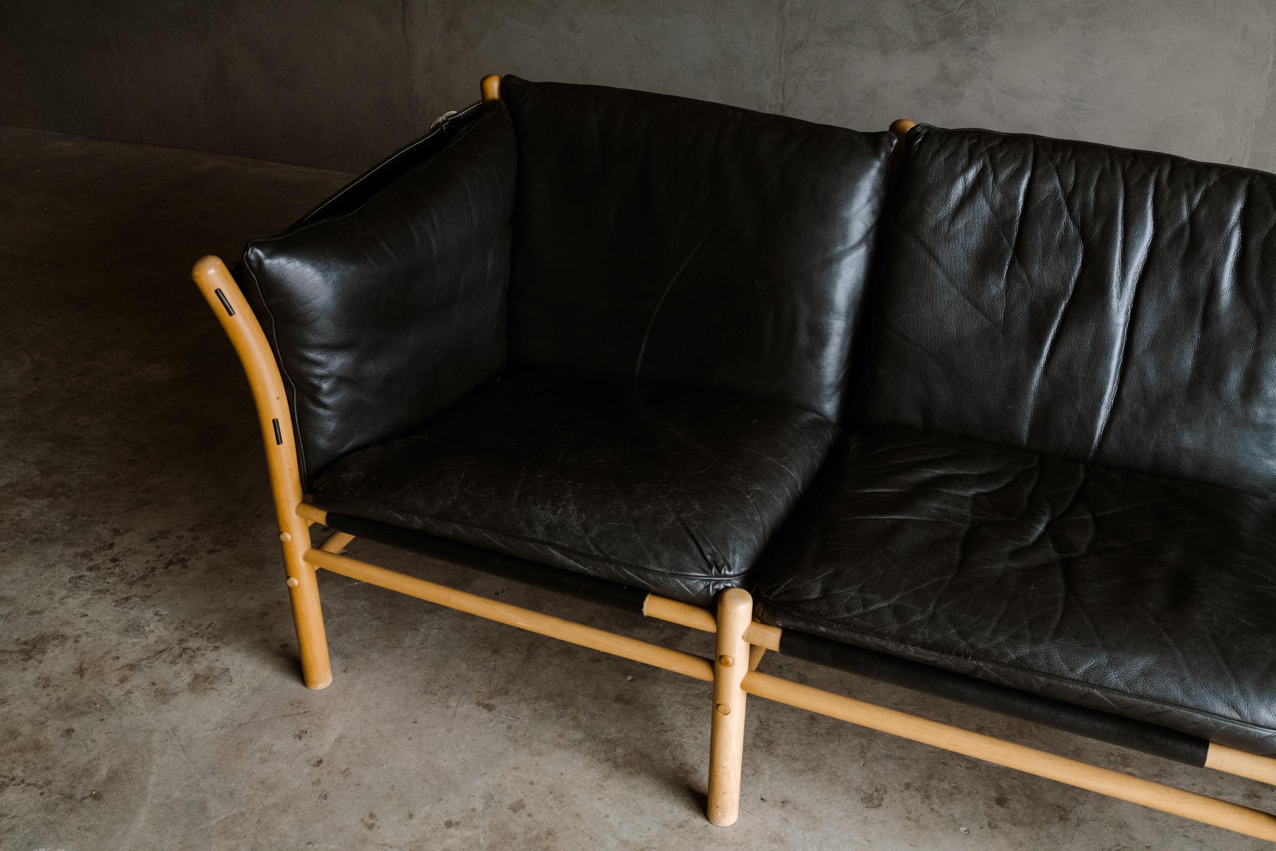 Vintage Arne Norell sofa model Ilona by Arne Norell AB in Sweden. Three-seat sofa with black leather cushions and a sold birch frame. Light wear and use.