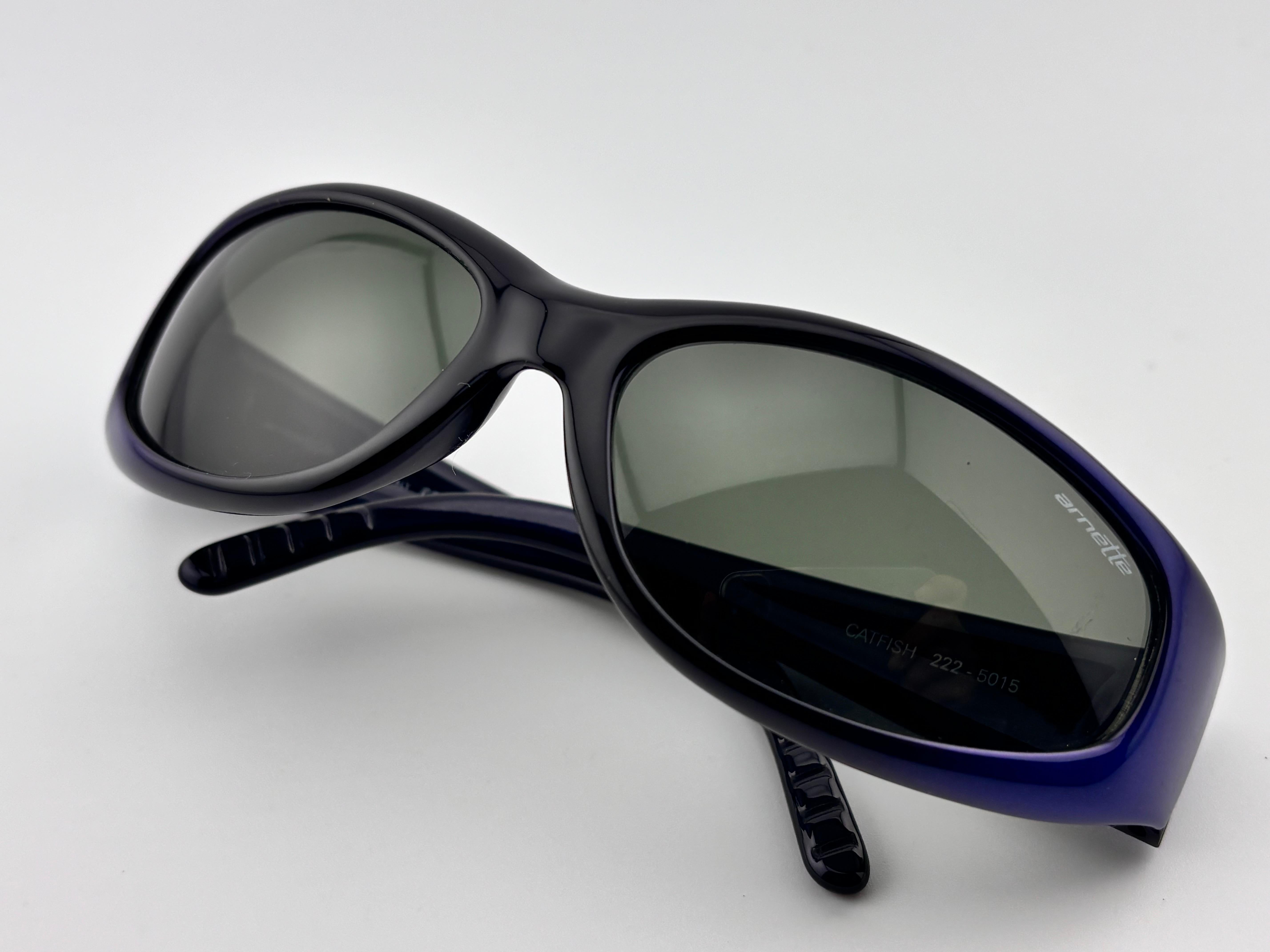 New Vintage Arnette Sleek Metallic Blue Wrap Around Sunglasses Sporting Grey Lenses.

Produit et Design/One au début des années 2000. 


Il présente une légère usure due à 30 ans de stockage.

Devant : 17 cm

Hauteur de l'objectif : 3 cm

Largeur de