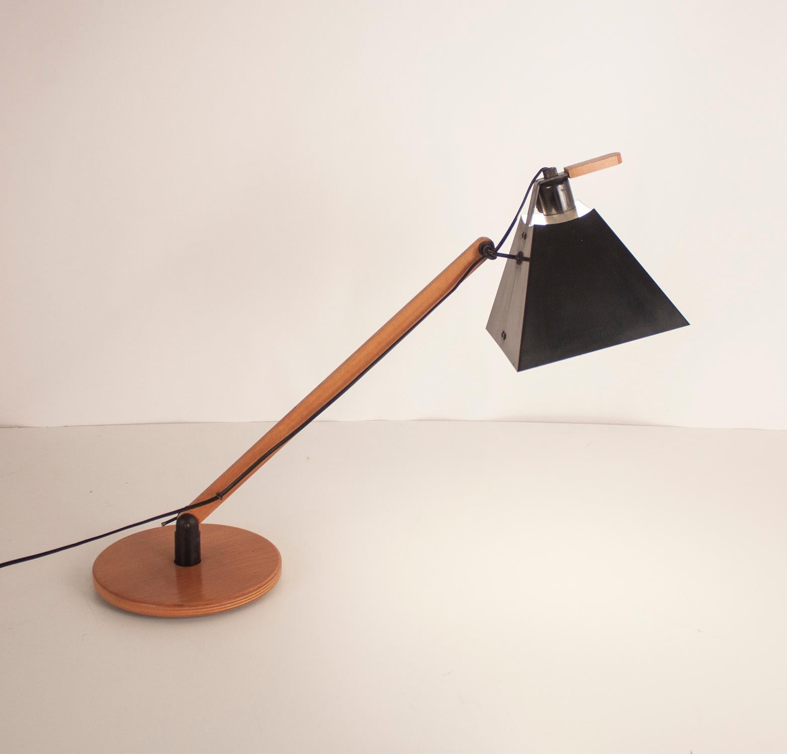 In 1974 the Barcelona designers Gemma Bernal and Ramón Isern designed this innovative system of lamps edited by Tramo.

In this tabletop version, a square-conical shade in black lacquered aluminum is attached to a circular base through an adjustable